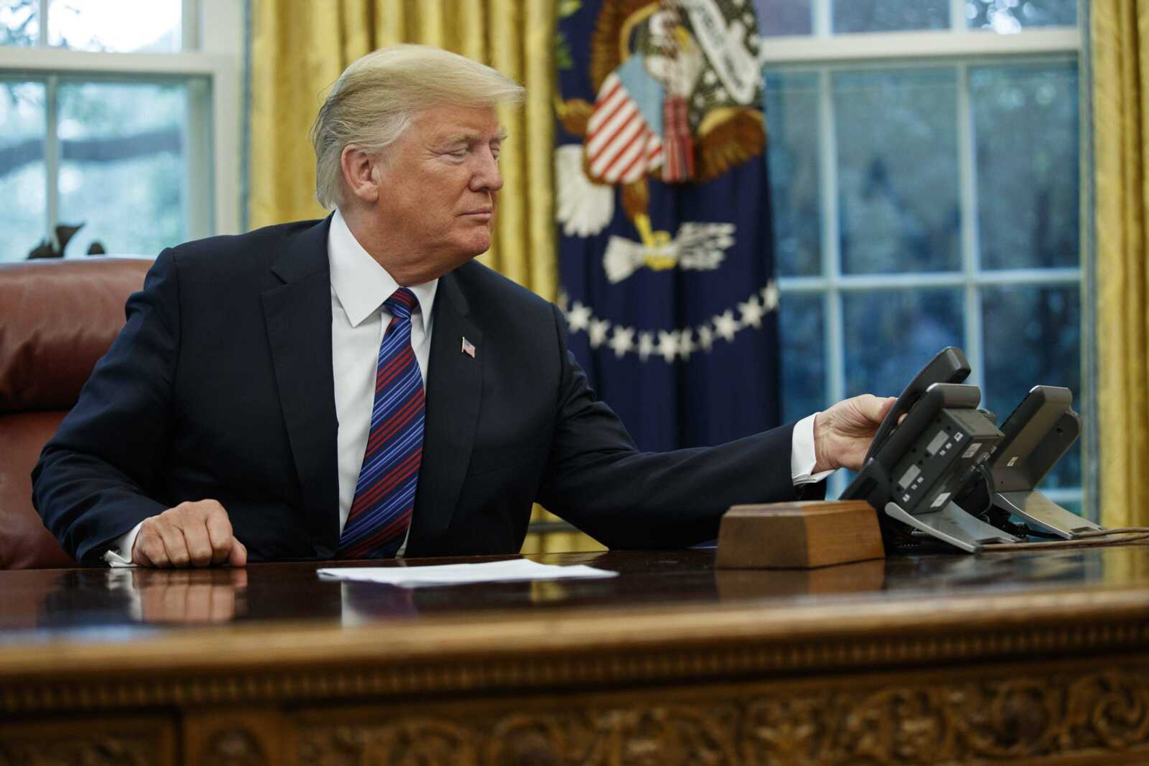 President Donald Trump hangs up the phone Monday after talking with Mexican President Enrique Pena Nieto in the Oval Office of the White House. Trump is announcing a trade "understanding" with Mexico that could lead to an overhaul of the North American Free Trade Agreement.