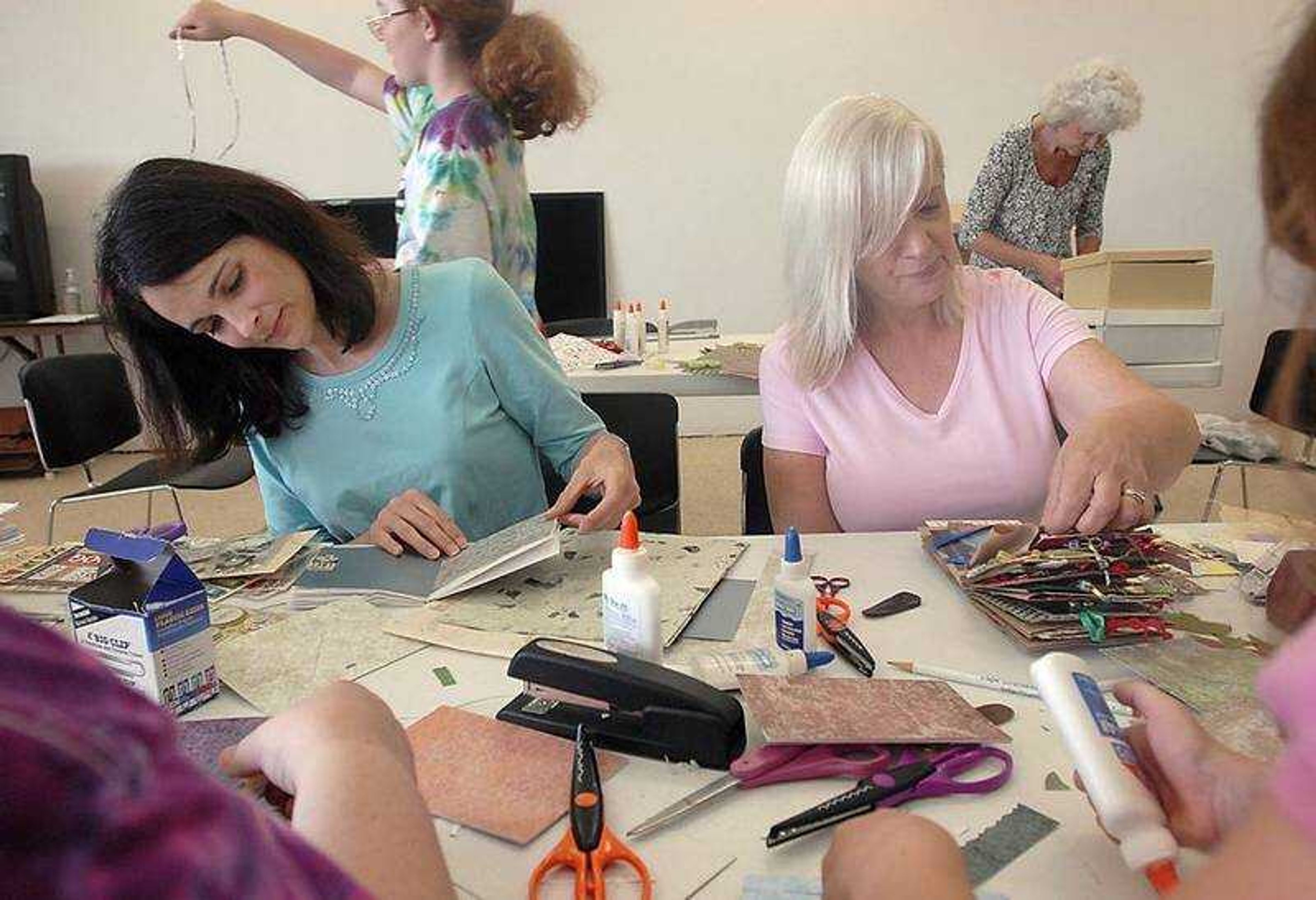 KIT DOYLE ~ kdoyle@semissourian.com
Wendy Lincoln, left, and Paula Fetherstone constructed paper bag memory books Saturday morning, July 12, 2008, durin gan Adult Services Program at the Cape Girardeau Public Library.  The new library will have twice the meeting room space as the old one, and much more than the current temporary location.  Youth Services and Adult Services currently juggle space to accomodate programs.