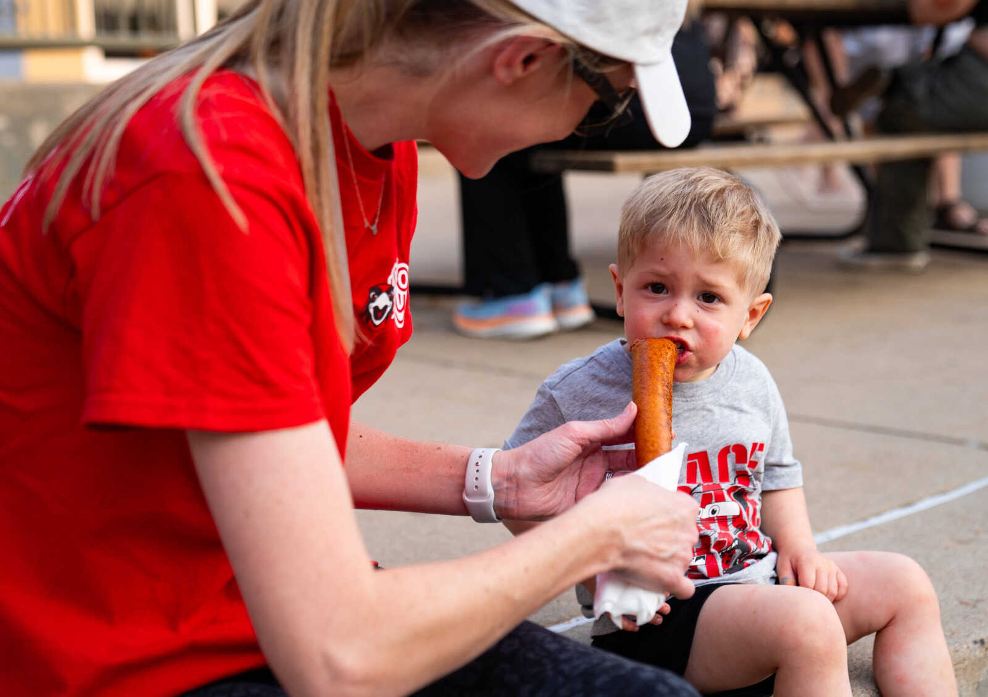 Amanda Mitsdarfer, left, feeds Will Mitsdarfer a bite of her corn dog Monday, Sept. 9, at the SEMO District Fair at Arena Park in Cape Girardeau. 