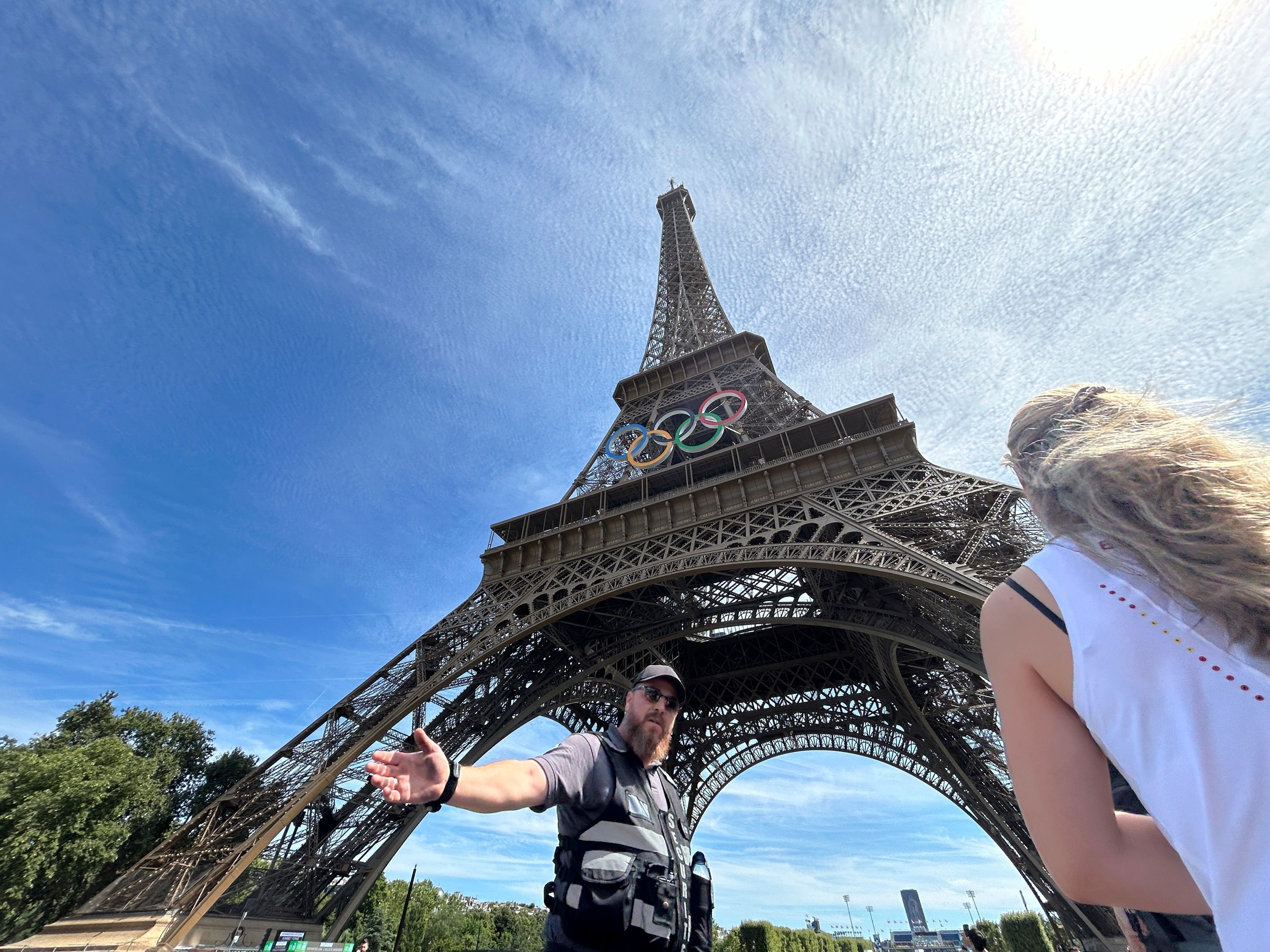 Police evacuate the area around the Eiffel Tower after a man was seen climbing the historic landmark, during the 2024 Summer Olympics, Sunday, Aug. 11, 2024, in Paris France. (AP Photo/Aijaz Rahi)