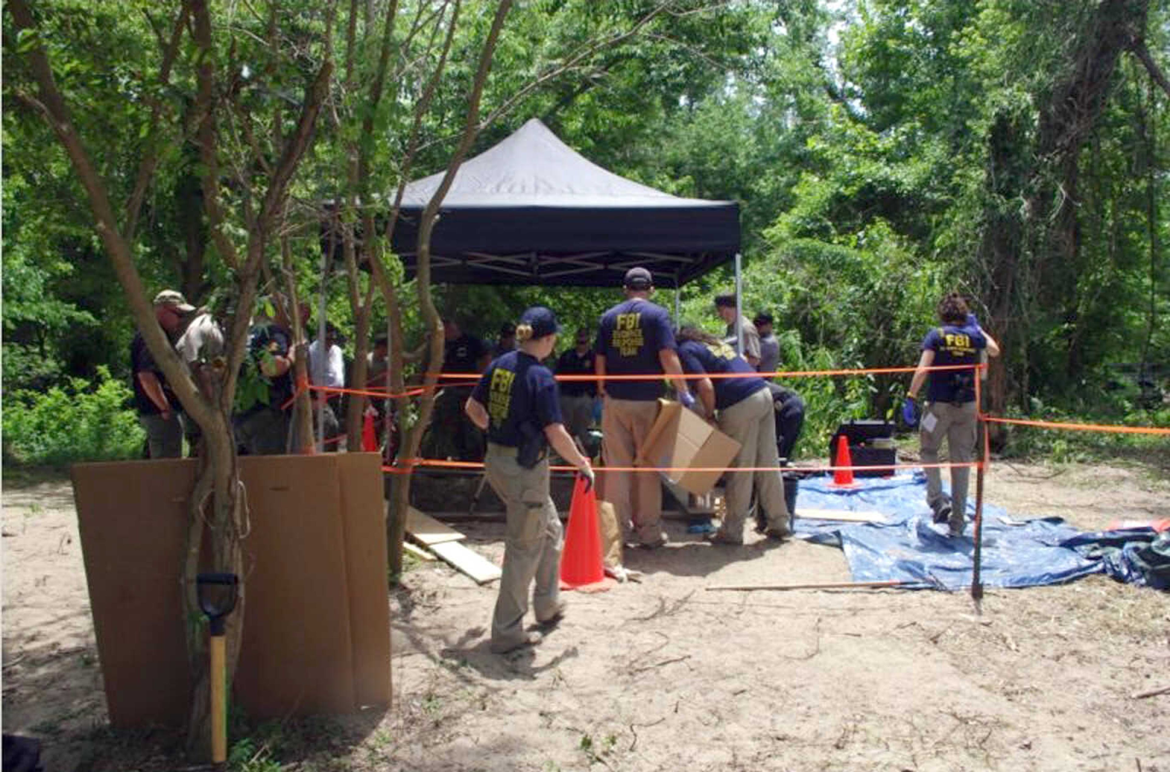 This photo submitted by Lt. David James shows FBI and local authorities digging at the site where Jacque Waller was buried by her husband, Clay Waller, after her death on June 1, 2011.