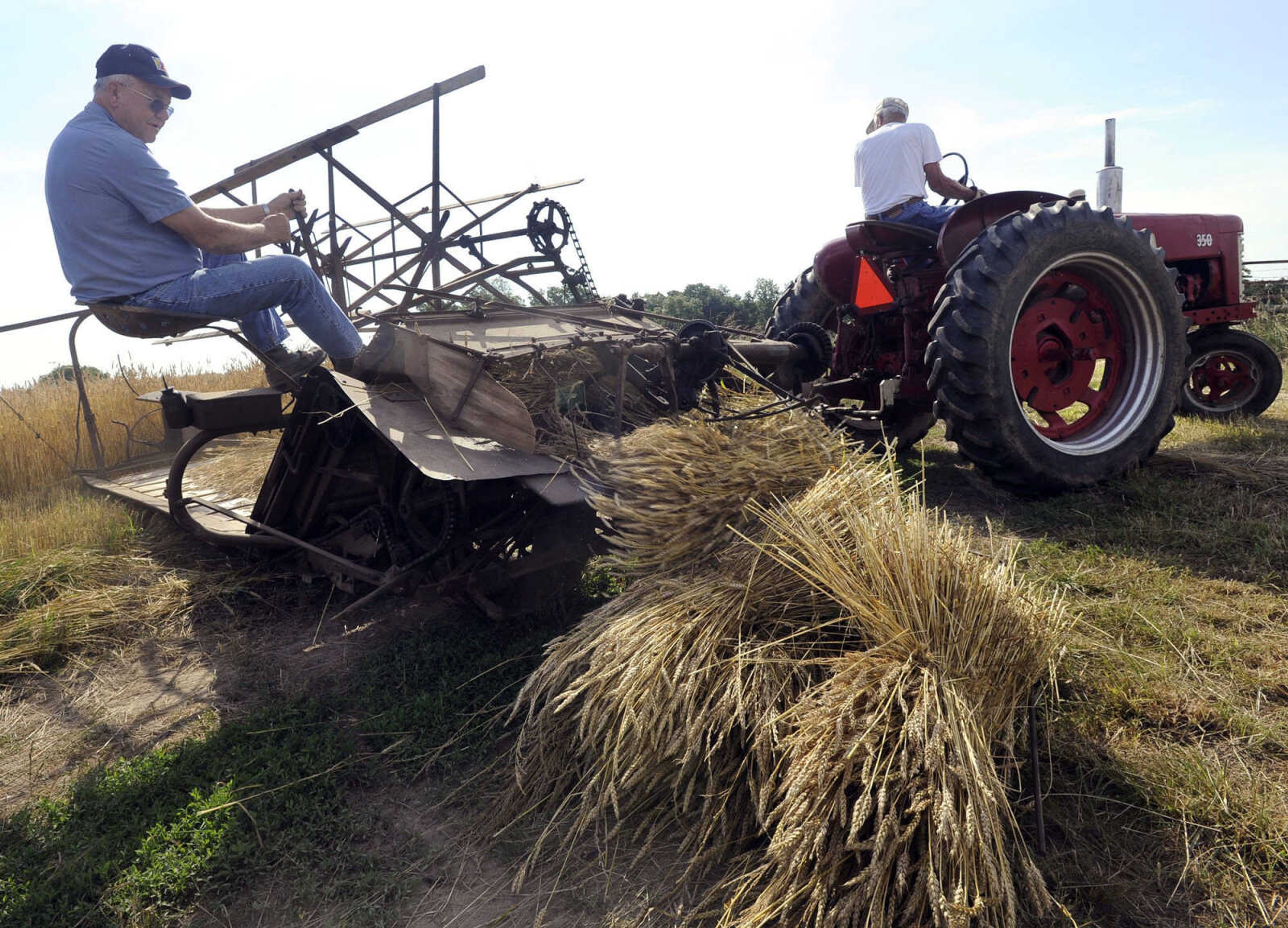 FRED LYNCH ~ flynch@semissourian.com
Larry Brockmier operates a late-1930s McCormick-Deering wheat binder behind a tractor driven by George "Dude" Huey as they harvested an acre of wheat Saturday, June 15, 2013 at the Huey farm north of Cape Girardeau. The wheat will be dried for threshing demonstrations at Egypt Fest to be held Aug. 17-18 at Egypt Mills. A video of the binder operation is available at semissourian.com/multimedia.