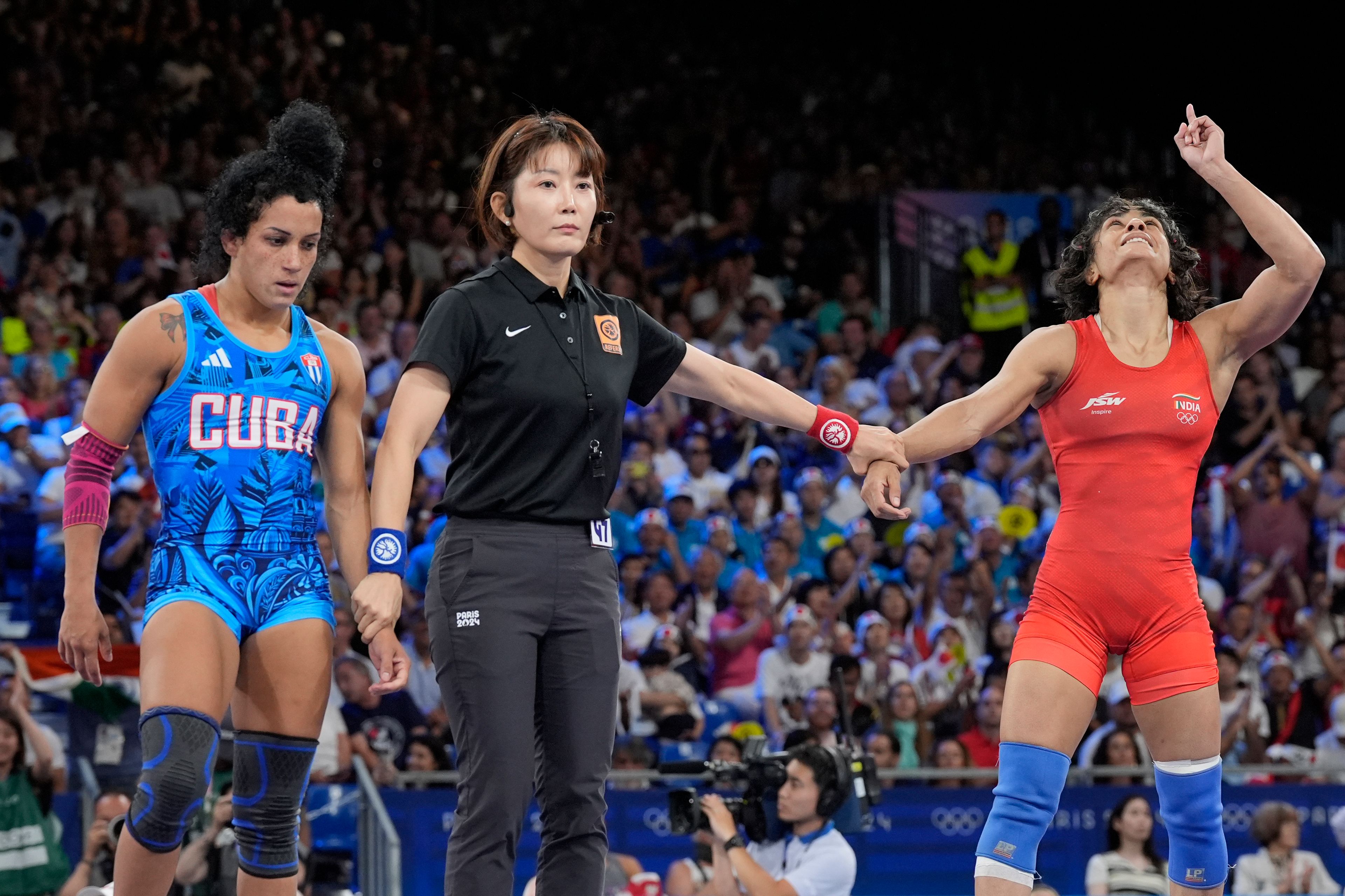 India's Vinesh Vinesh, right, celebrates after defeating Cuba's Yusneylys Guzman compete during their women's freestyle 50kg wrestling semifinal match, at Champ-de-Mars Arena, during the 2024 Summer Olympics, Tuesday, Aug. 6, 2024, in Paris, France. (AP Photo/Eugene Hoshiko)