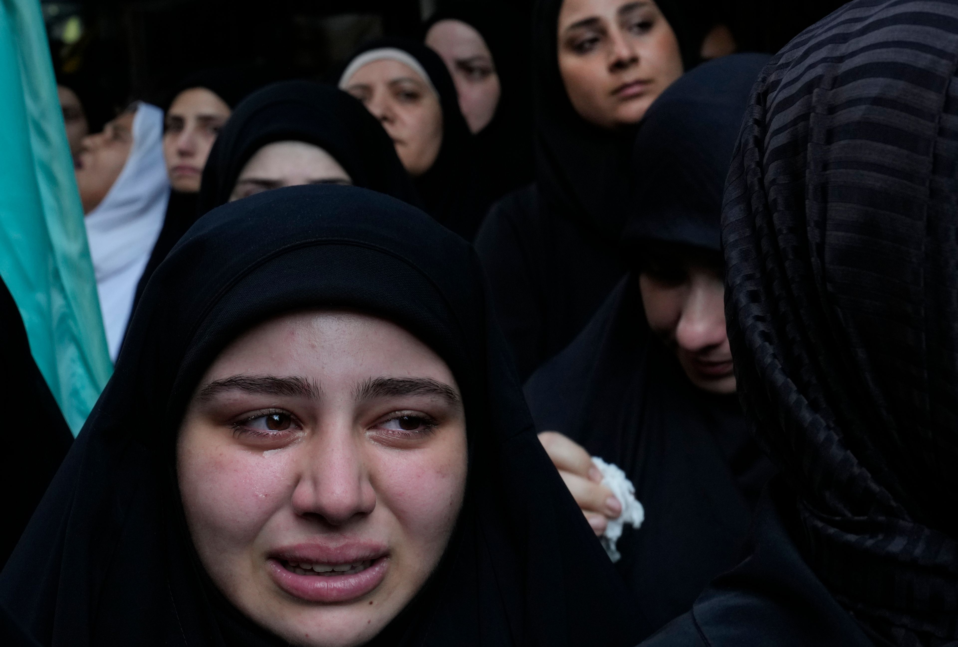 A woman cries during the funeral procession of two Hezbollah members, killed when a handheld device exploded, in the southern suburbs of Beirut, Lebanon, Thursday, Sept. 19, 2024. (AP Photo/Hussein Malla)