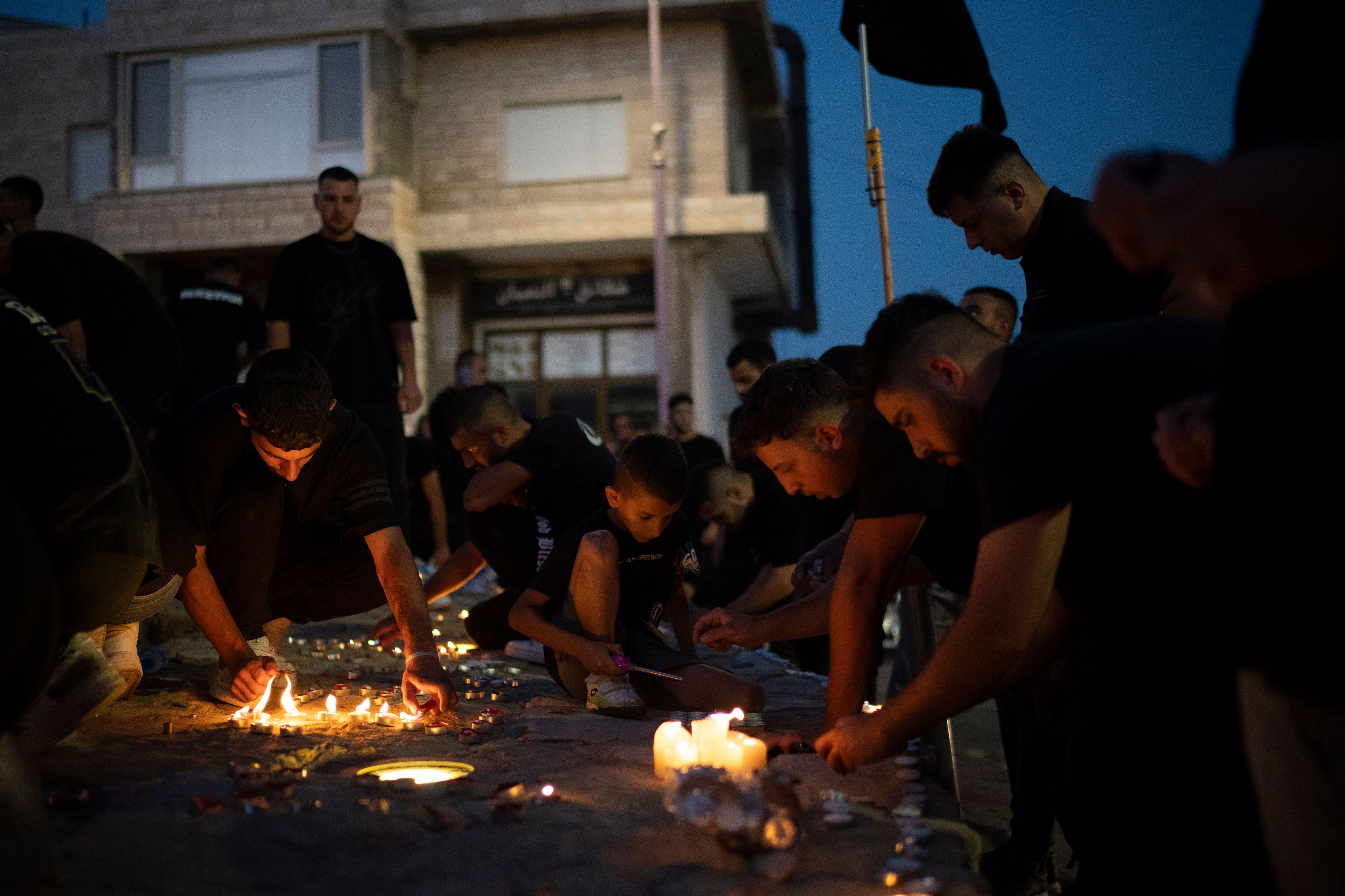 People light candles in memory of the children and teens killed in a rocket strike at a soccer field at the village of Majdal Shams, in the Israeli-annexed Golan Heights, Sunday, July 28, 2024. A rocket strike at a soccer field in the village has killed at least 12 children and teens. It's the deadliest strike on an Israeli target along the country's northern border since the fighting between Israel and the Lebanese militant group Hezbollah began. (AP Photo/Leo Correa)