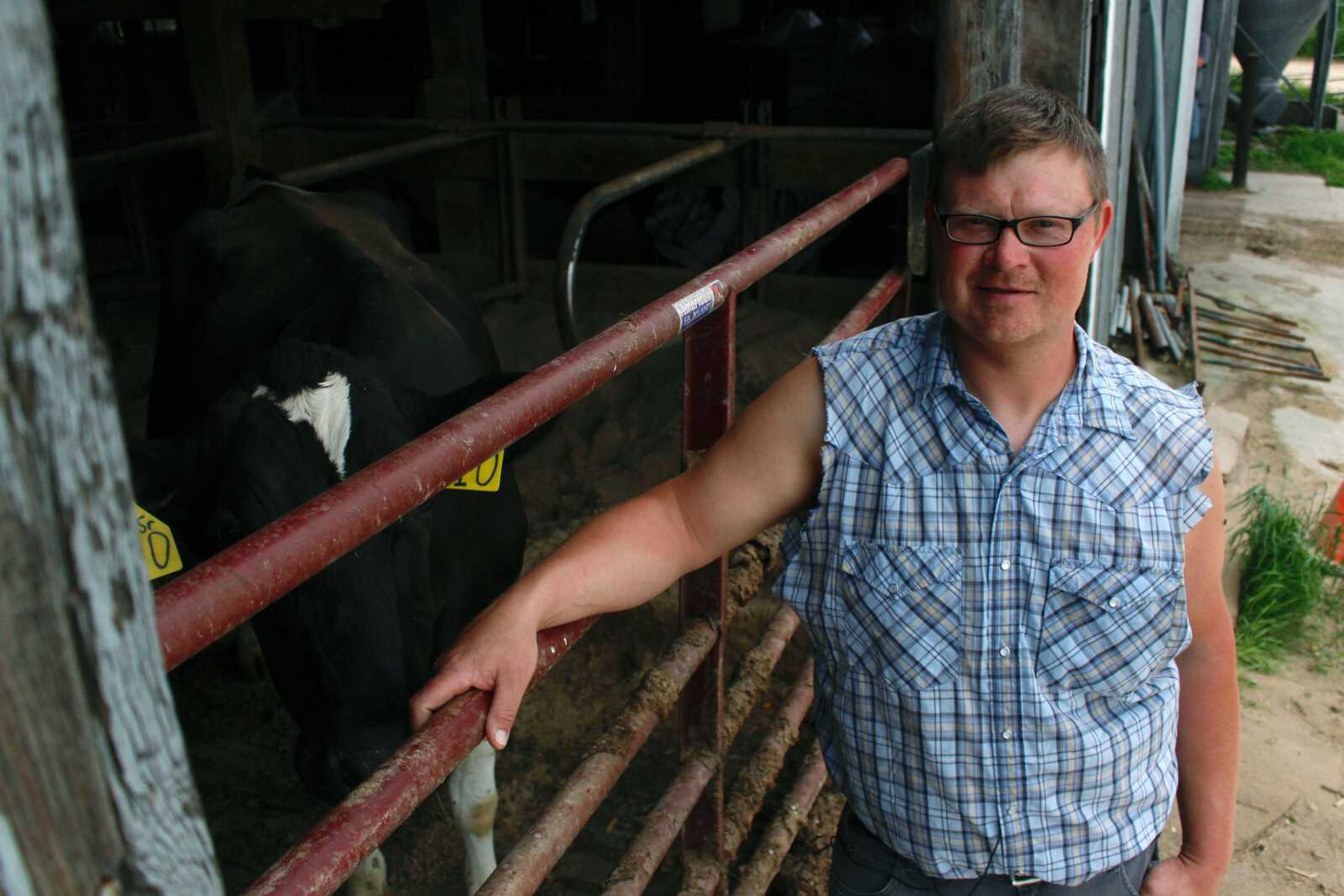 Ryan Brueggemann stands near his cows June 14 on a New Berlin, Wisconsin, dairy farm. He and his brother are renting the land and equipment from a retiring farmer, but want to buy their own farm. They can't afford it now due to low milk prices and tariffs on grains and milk. But Brueggemann thinks the economy is moving along well and supports President Donald Trump.