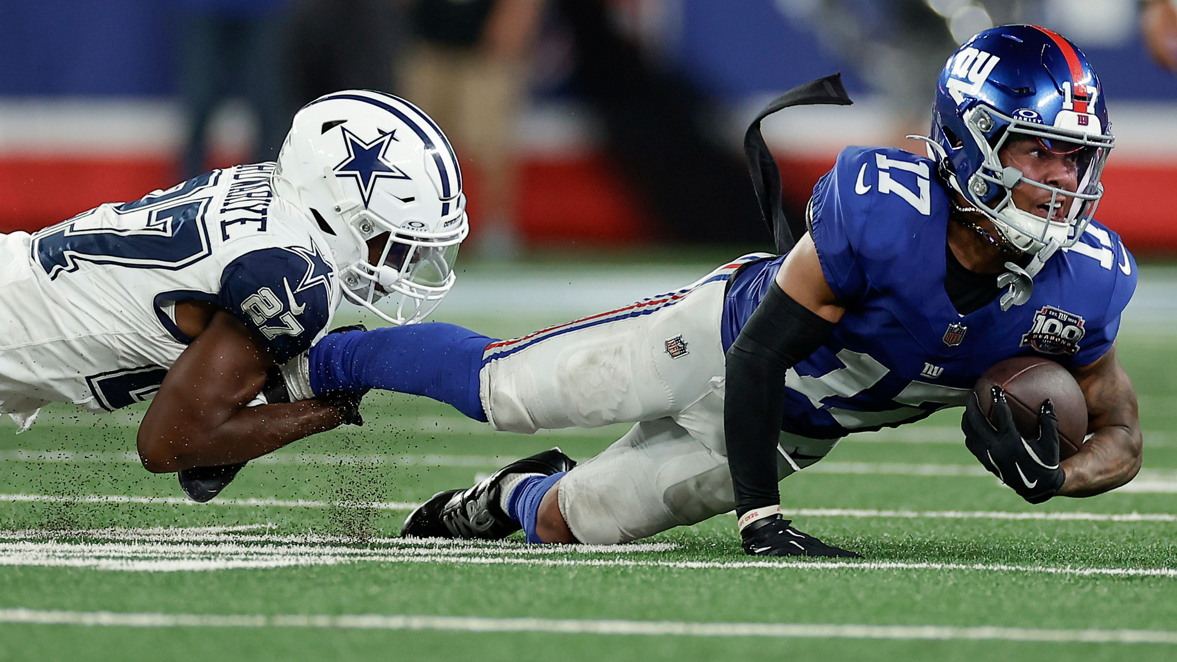 Dallas Cowboys cornerback Amani Oruwariye (27) pulls down New York Giants wide receiver Wan'Dale Robinson (17) during the fourth quarter of an NFL football game, Thursday, Sept. 26, 2024, in East Rutherford, N.J. (AP Photo/Adam Hunger)