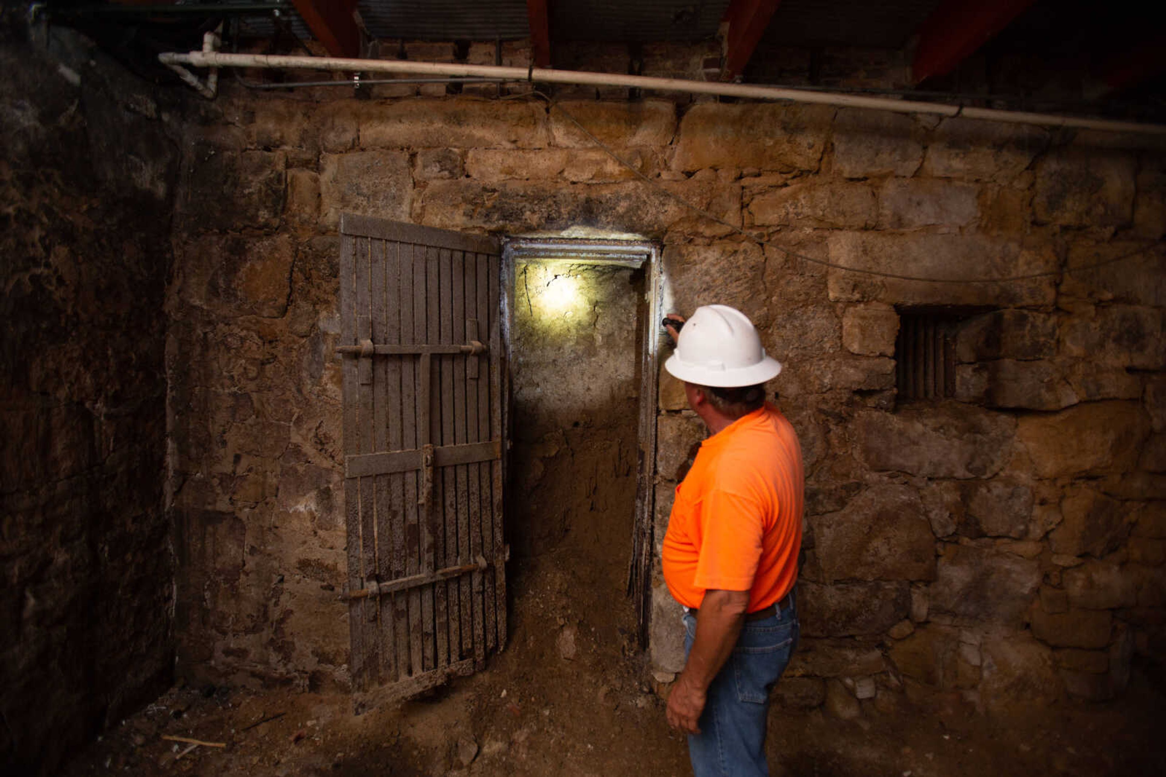 Project superintendent David Marigeaux of Penzel Construction shines a flashlight through a doorway of an old jail cell in the basement of the Common Pleas Courthouse on Tuesday, June 16, 2020.