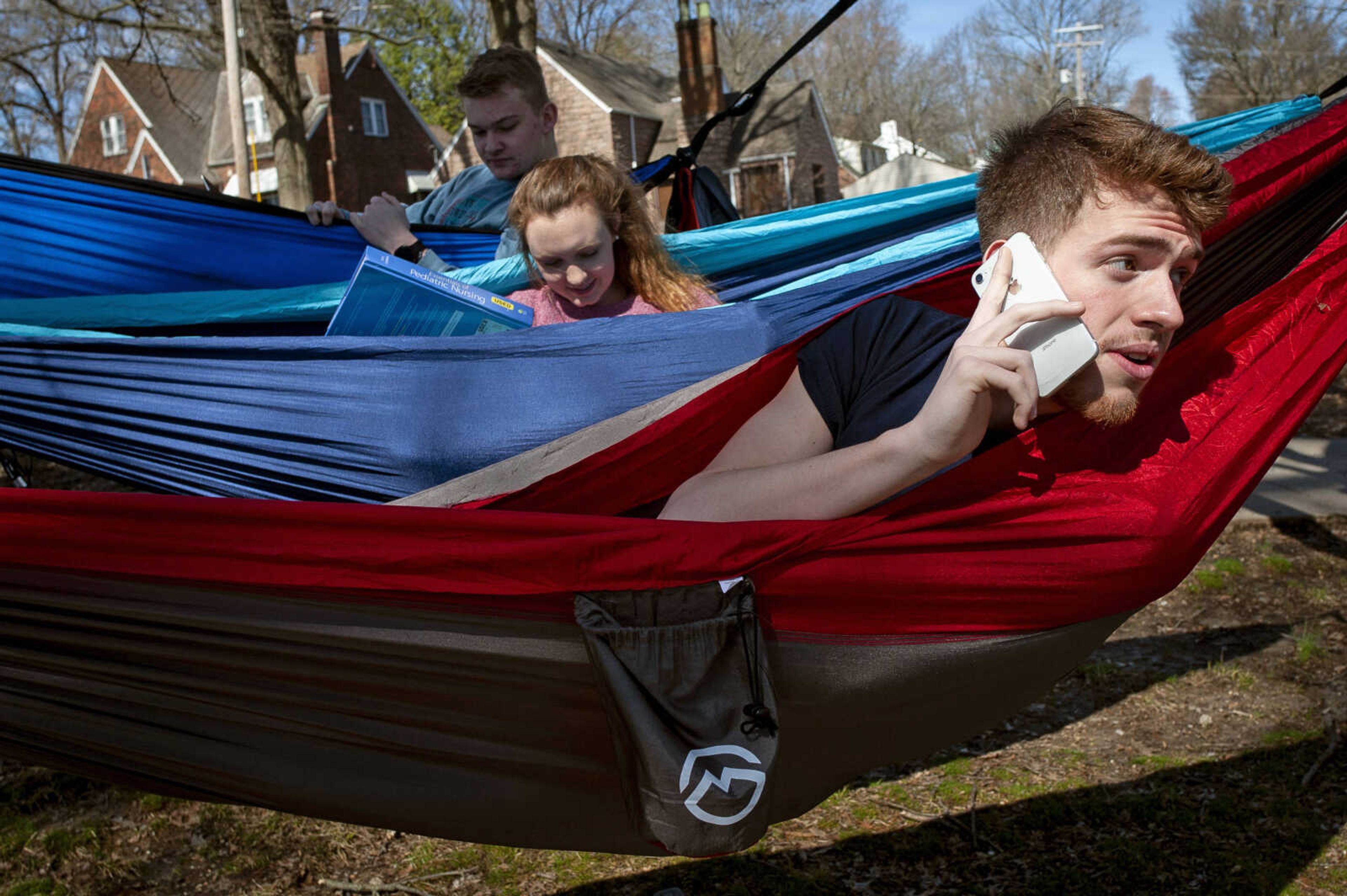 David Dugan of Charleston, Missouri, speaks on the phone with Ashley Freese of St. Louis, Missouri, who was about the join the hammocking group of Southeast Missouri State University students including Harley Allen of Dexter, Missouri, (middle) and Ashton Hopper of Cape Girardeau (in background) on Tuesday, March 3, 2020, at Capaha Park in Cape Girardeau. "It's beautiful out here," Dugan said. "It's really peaceful to come out here and just enjoy nature, enjoy God's creation."