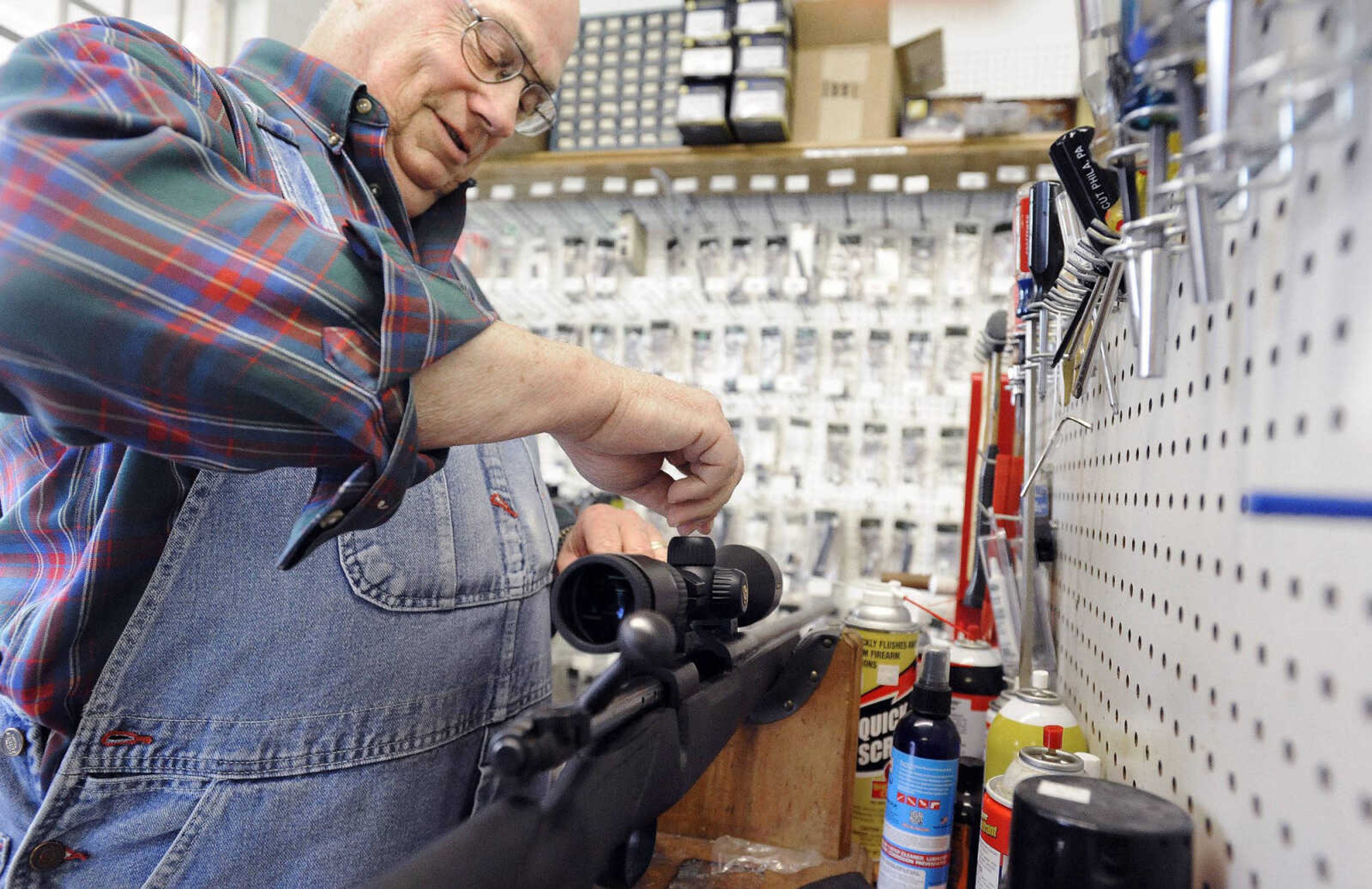 Ron Hartline adjusts a new scope range on a customer's Winchester model 7mm magnum Wednesday at Shooters Gun Shop in Cape Girardeau. (Laura Simon)