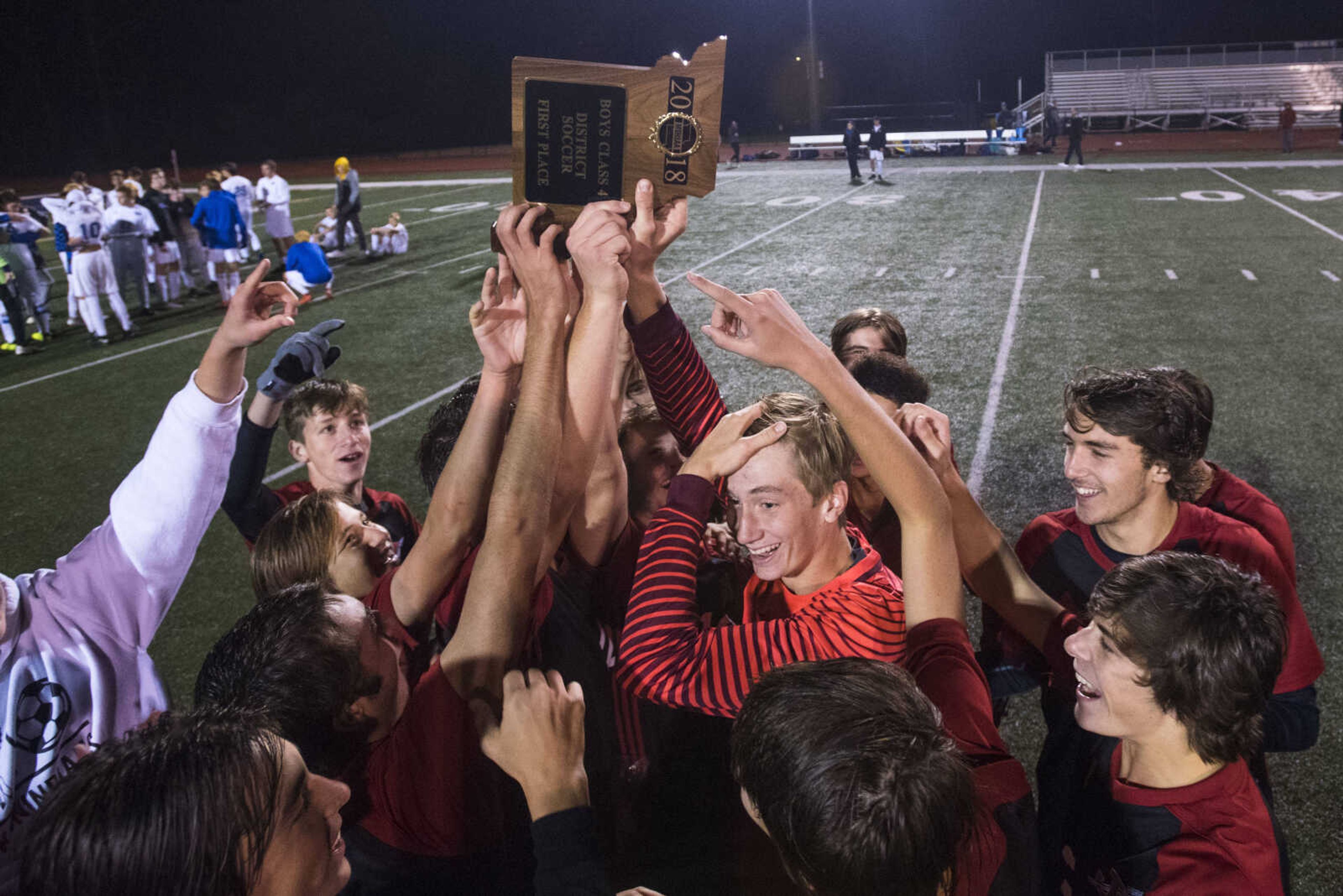 Jackson players celebrate at midfield with the district trophy after defeating Northwest in the Class 4 District 1 boys soccer championship game Thursday, Nov. 1, 2018, in Imperial, Missouri.