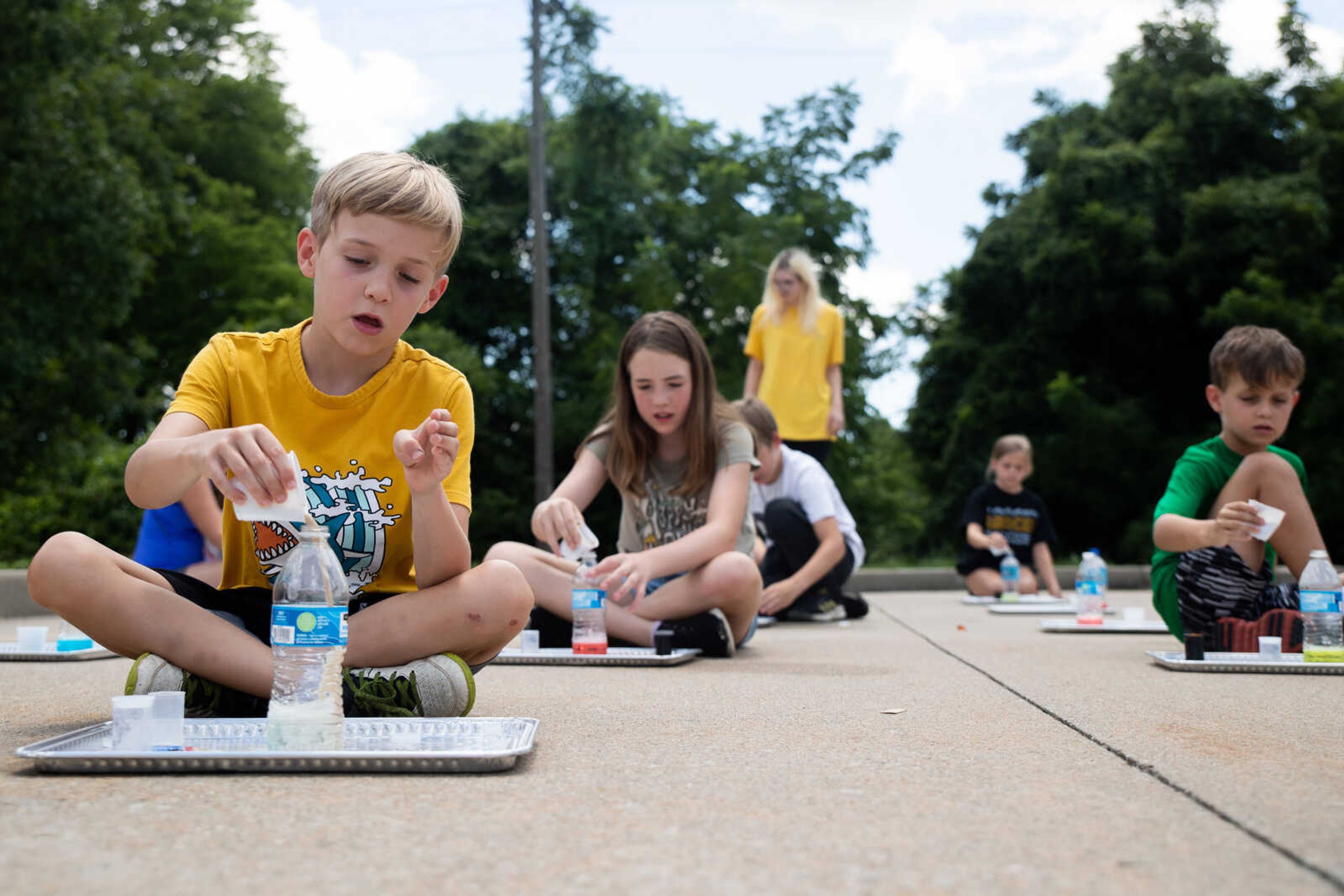 Daniel Young, 6, pours yeast into a water bottle during an experiment.