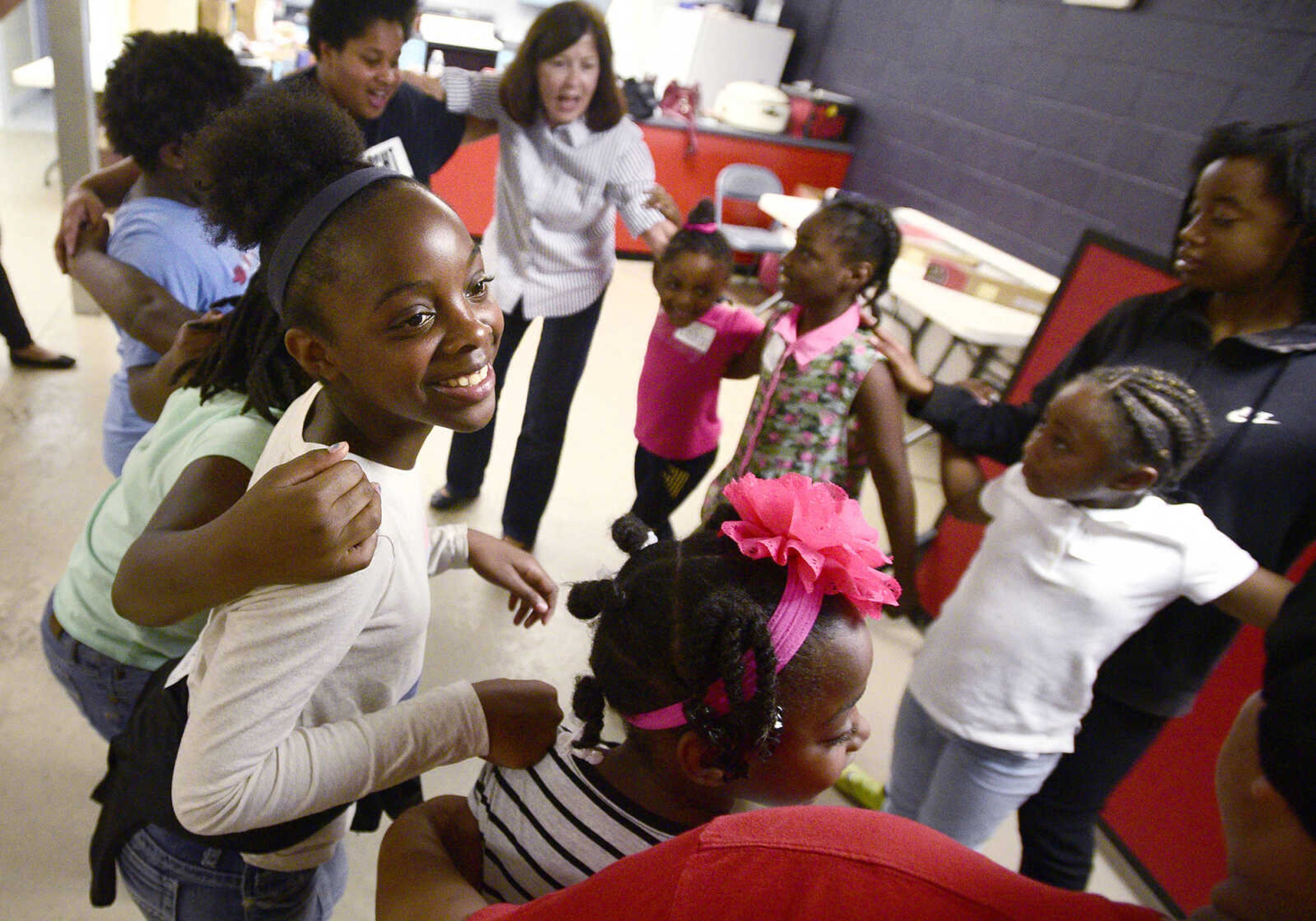 Marshauntis Washington looks up with a smile while dancing with her friends and volunteers on Monday, Aug. 14, 2017, during the Salvation Army's after school program at The Bridge Outreach Center in Cape Girardeau.