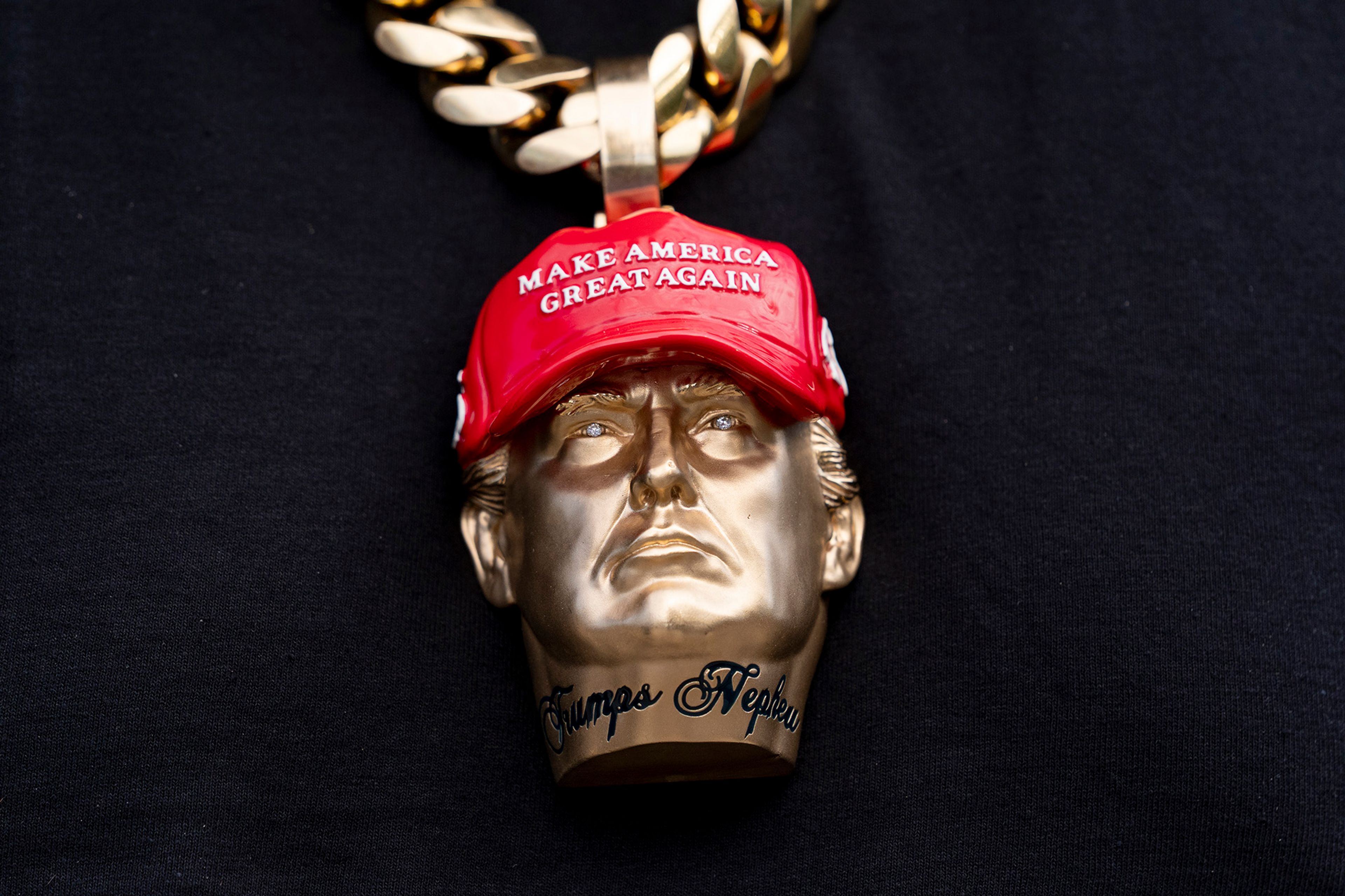 Forgiato Blow wears a necklace with a likeness of former President Donald Trump before Republican presidential nominee former President Donald Trump speaks at a campaign event at the Cobb Energy Performing Arts Centre, Tuesday, Oct. 15, 2024, in Atlanta.