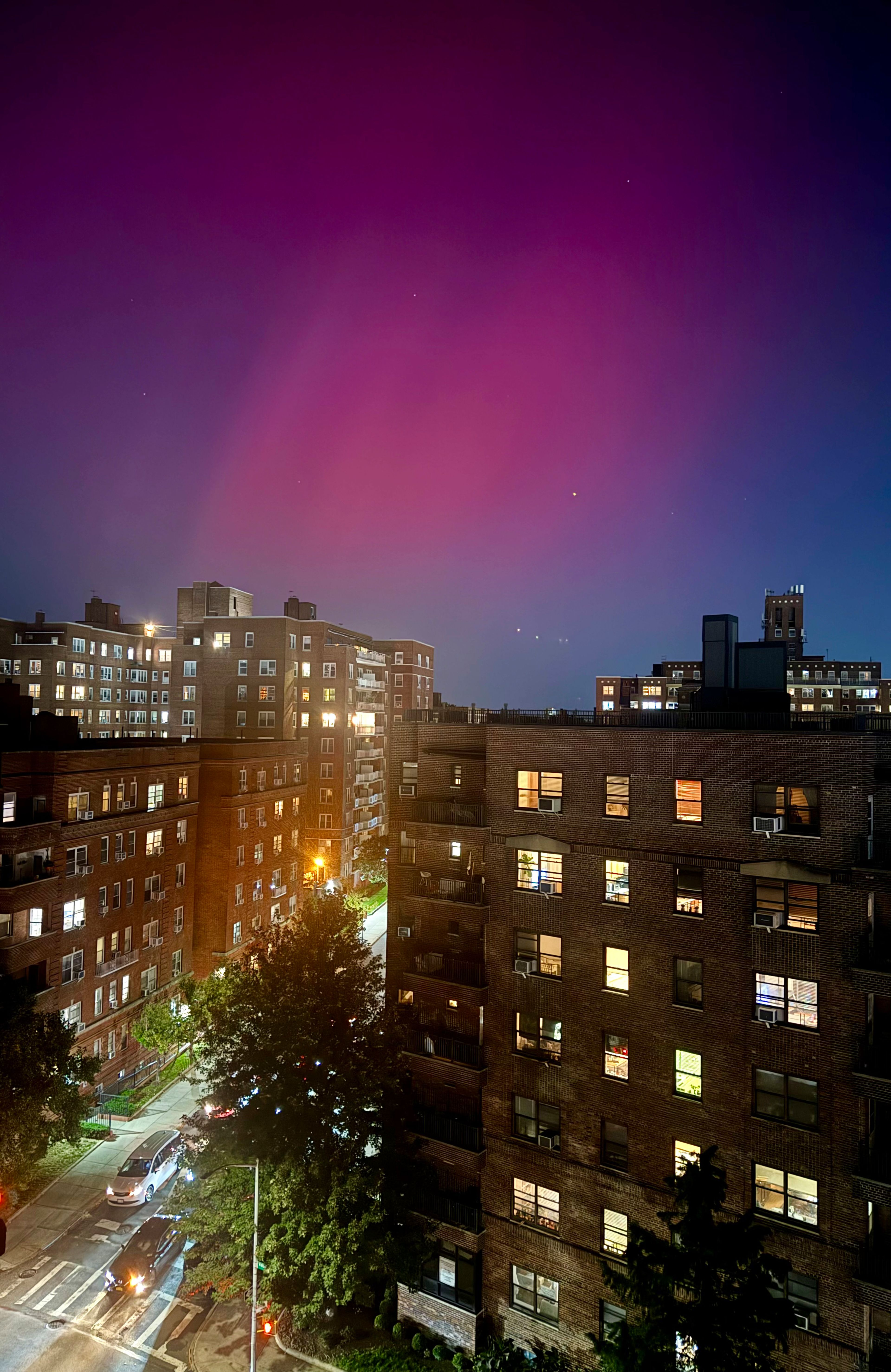 An aurora borealis, also known as the northern lights, glows in the night sky above apartment buildings in the Queens borough of New York, Thursday, Oct. 10, 2024. (AP Photo/Daniel P. Derella)