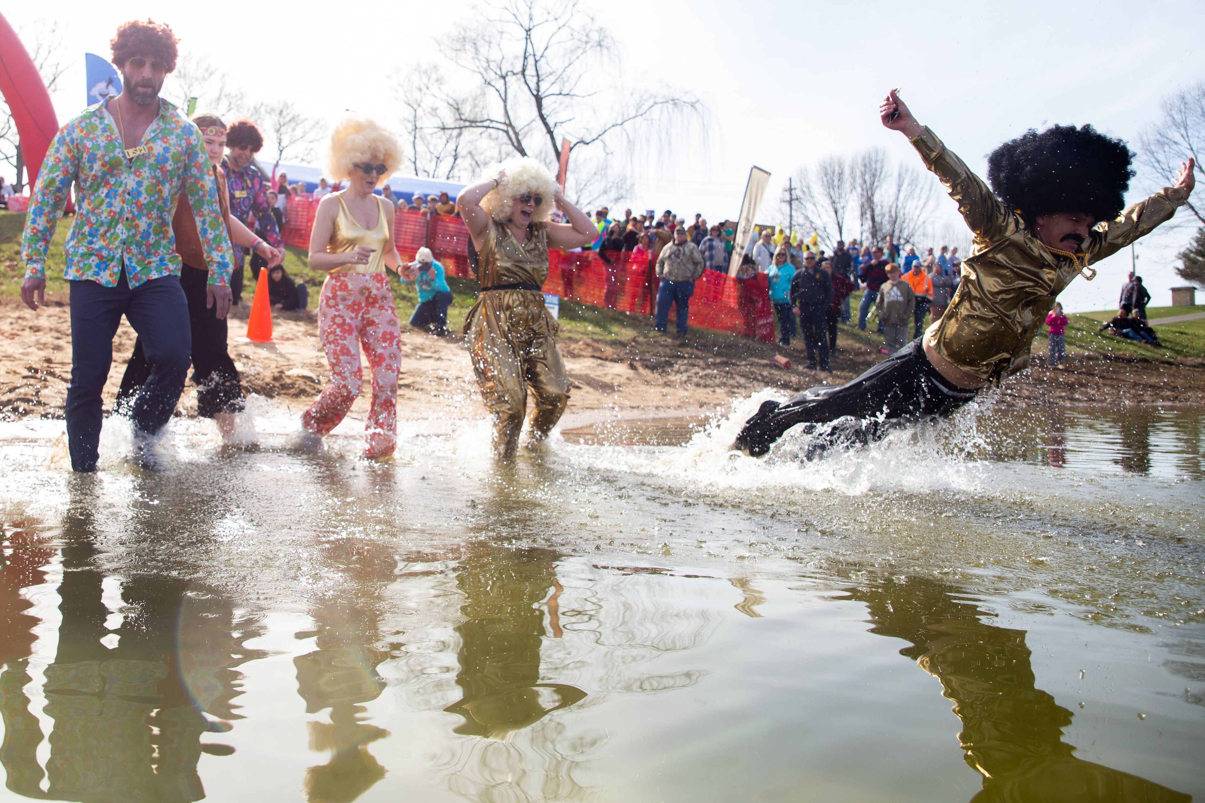 Paul Harrison, right, of the team “the Iced Age”, dives into the water at the Polar Plunge in 2023. This photo won first place in the best feature photograph category.