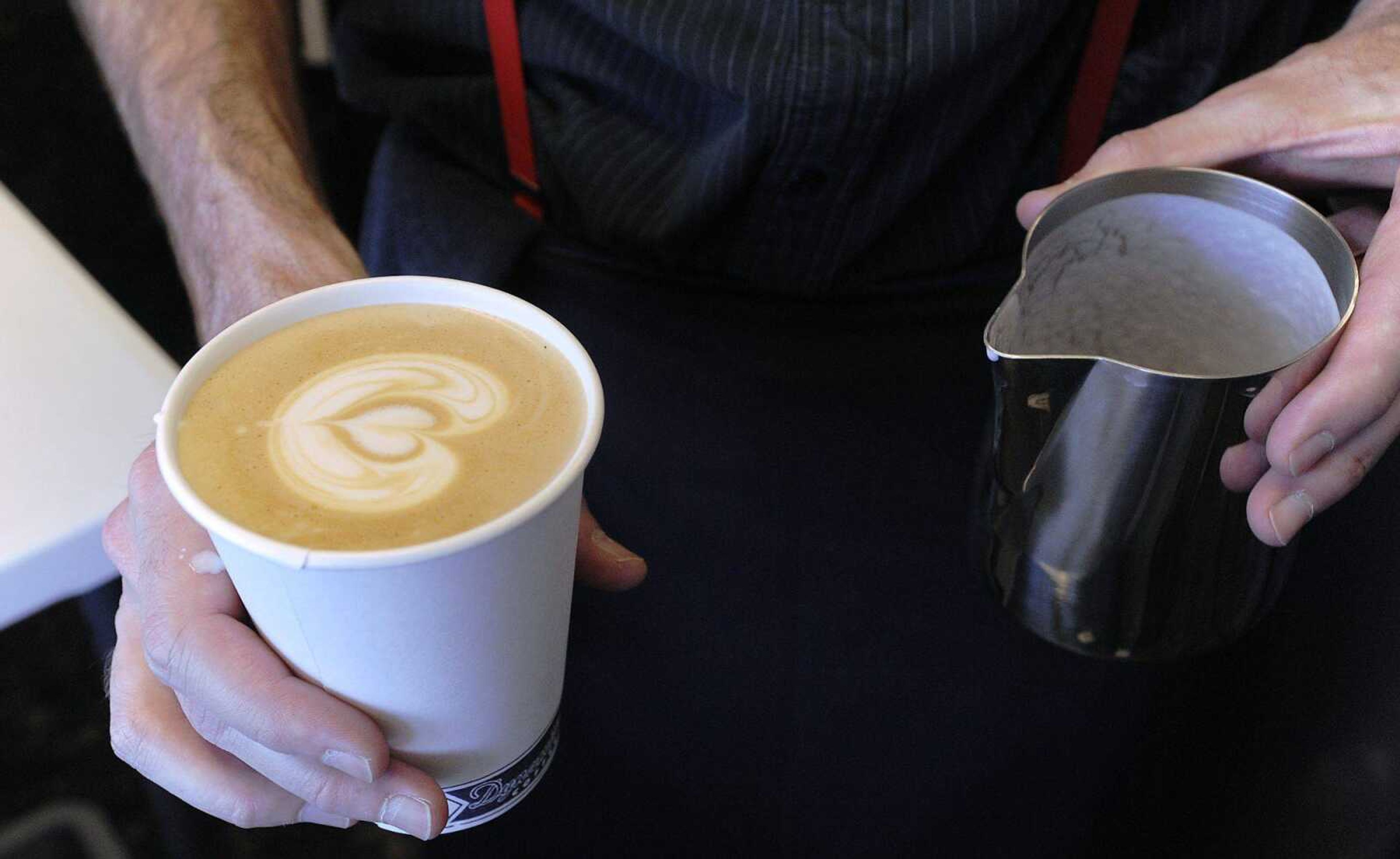 Dynamite Coffee owner Robbie Britt prepares a cappuccino at his coffee stand outside the main entrance of West Park Mall. Britt offers several coffee drinks as well as whole beans from his stand. (ADAM VOGLER)