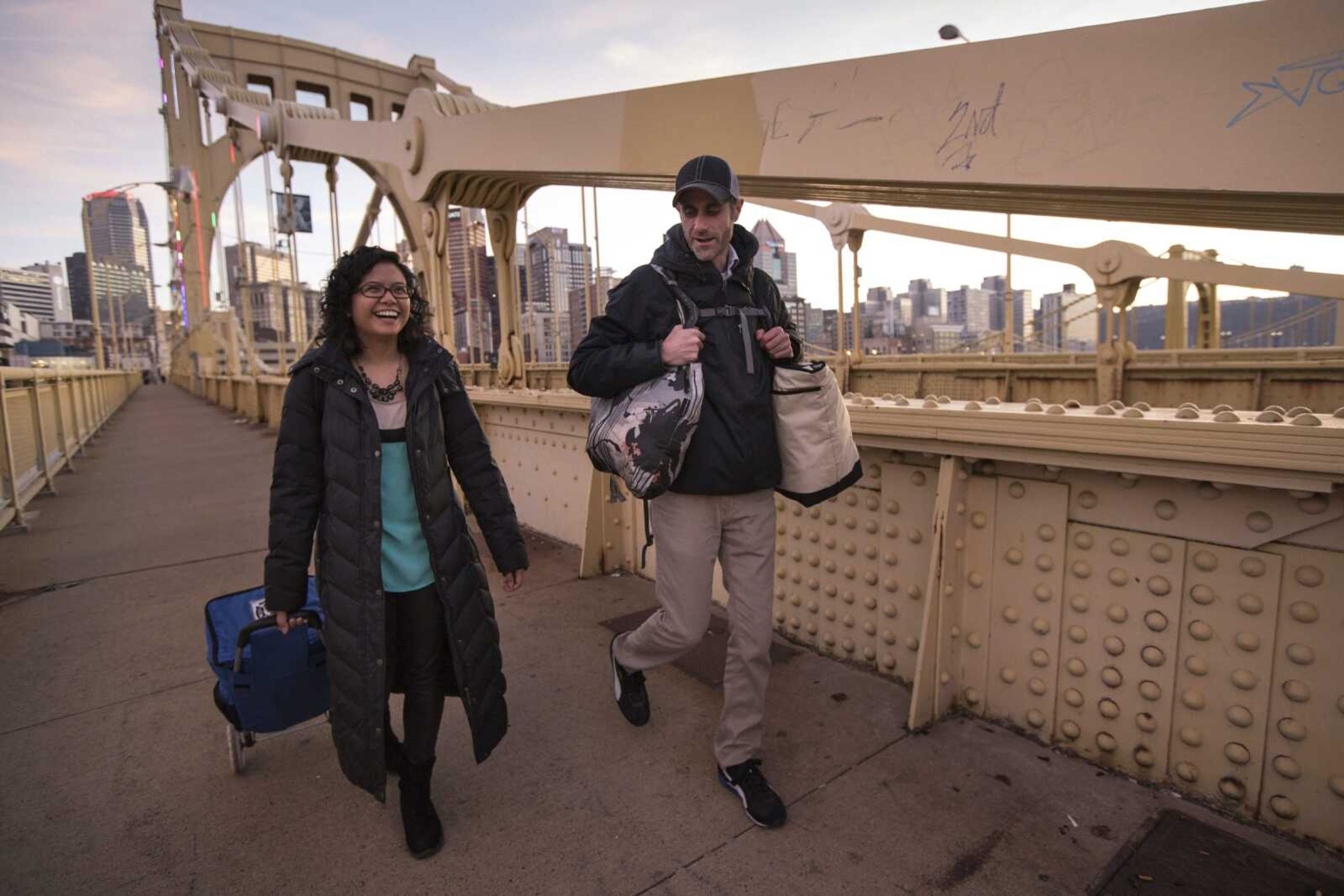 This image released by 412 Food Rescue shows Melinda Angeles and Eli Thomas transporting a donation of bagels from Bruegger's Bagels across the 9th Street bridge to a North Side senior center in Pittsburgh.