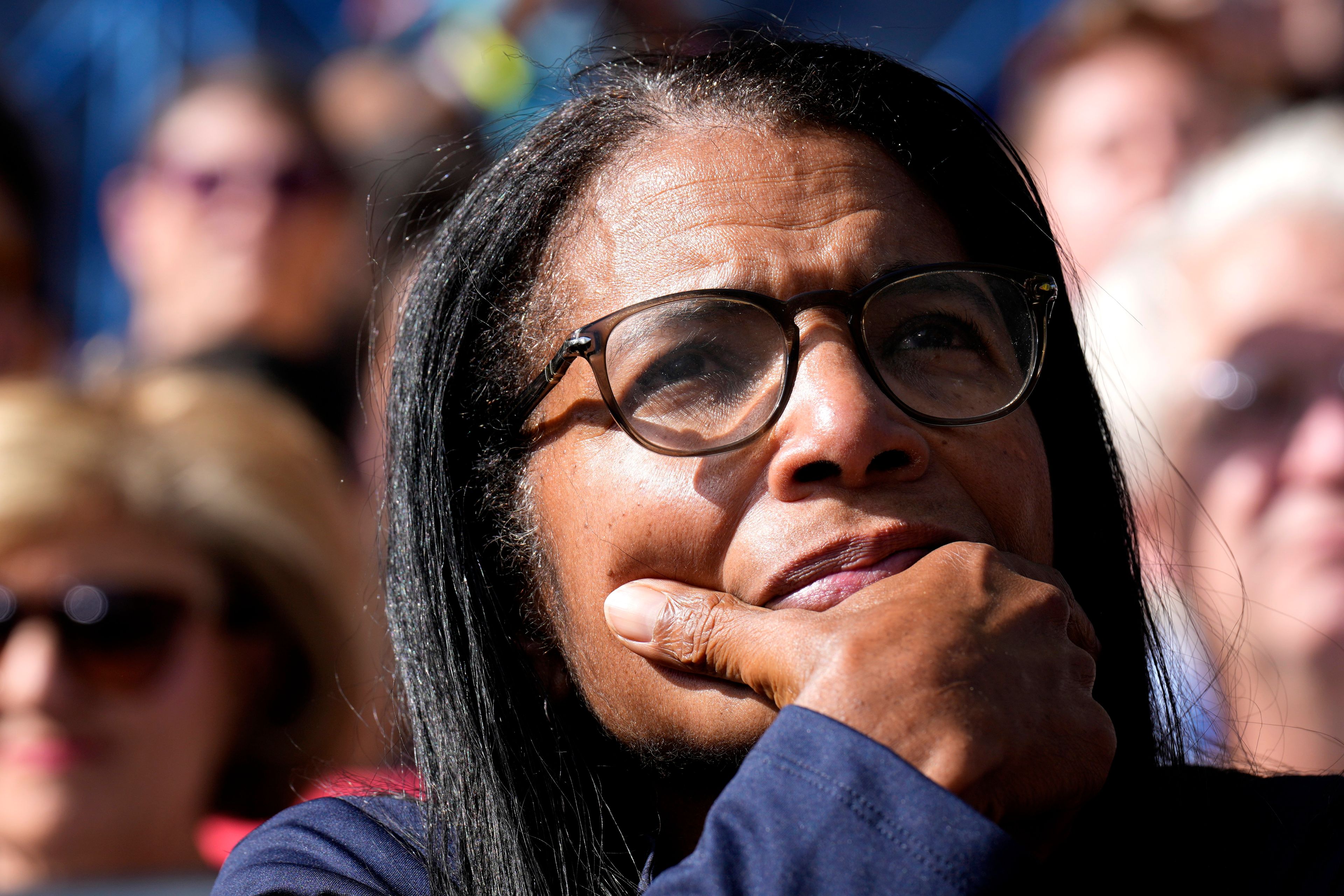 An attendee listens as Democratic presidential nominee Vice President Kamala Harris speaks during a campaign event at Riverside Park in Grand Rapids, Mich., Friday, Oct. 18, 2024. (AP Photo/Jacquelyn Martin)