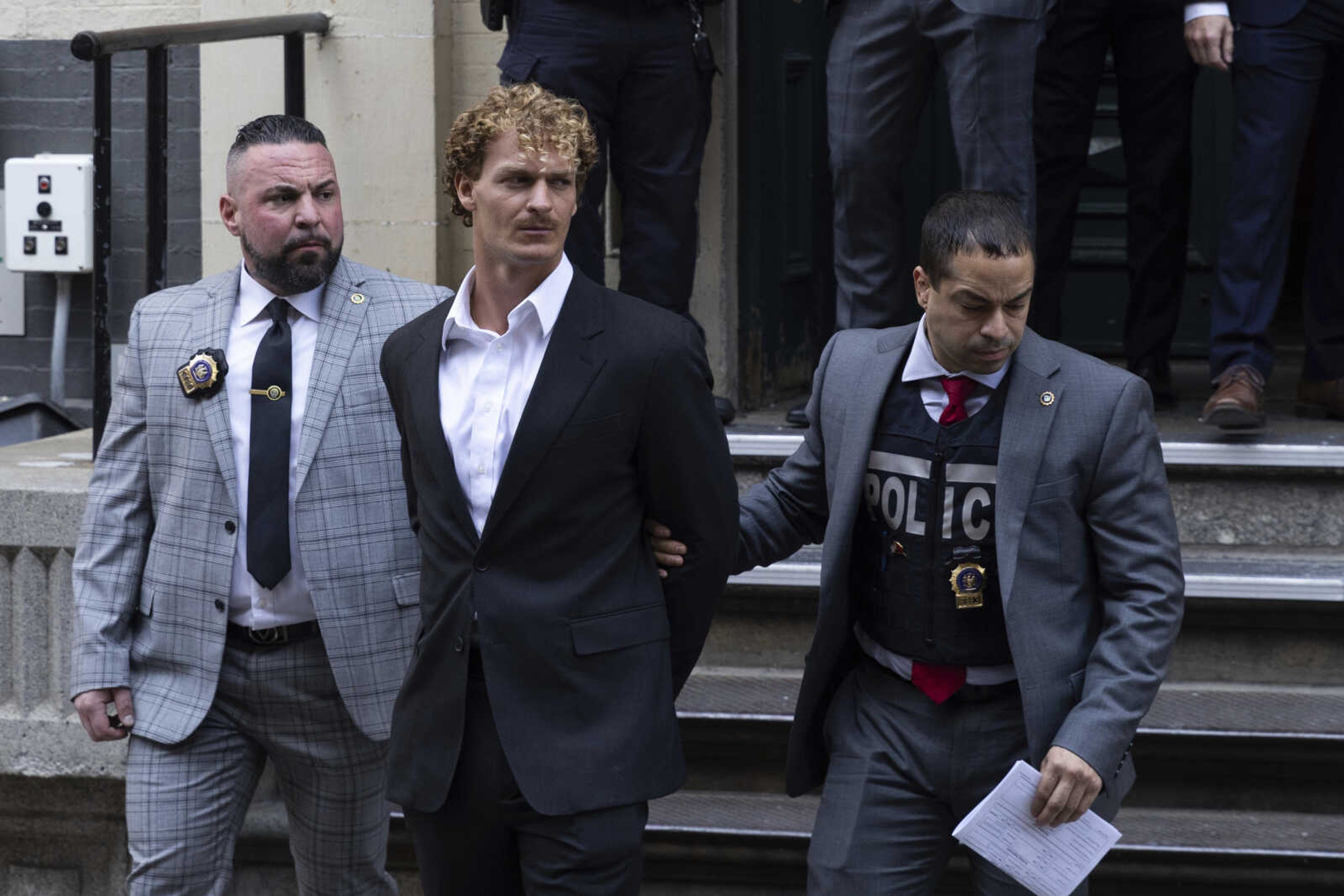 Daniel Penny, center, is walked by New York Police Department detectives out of the 5th Precinct on May 12 in New York.