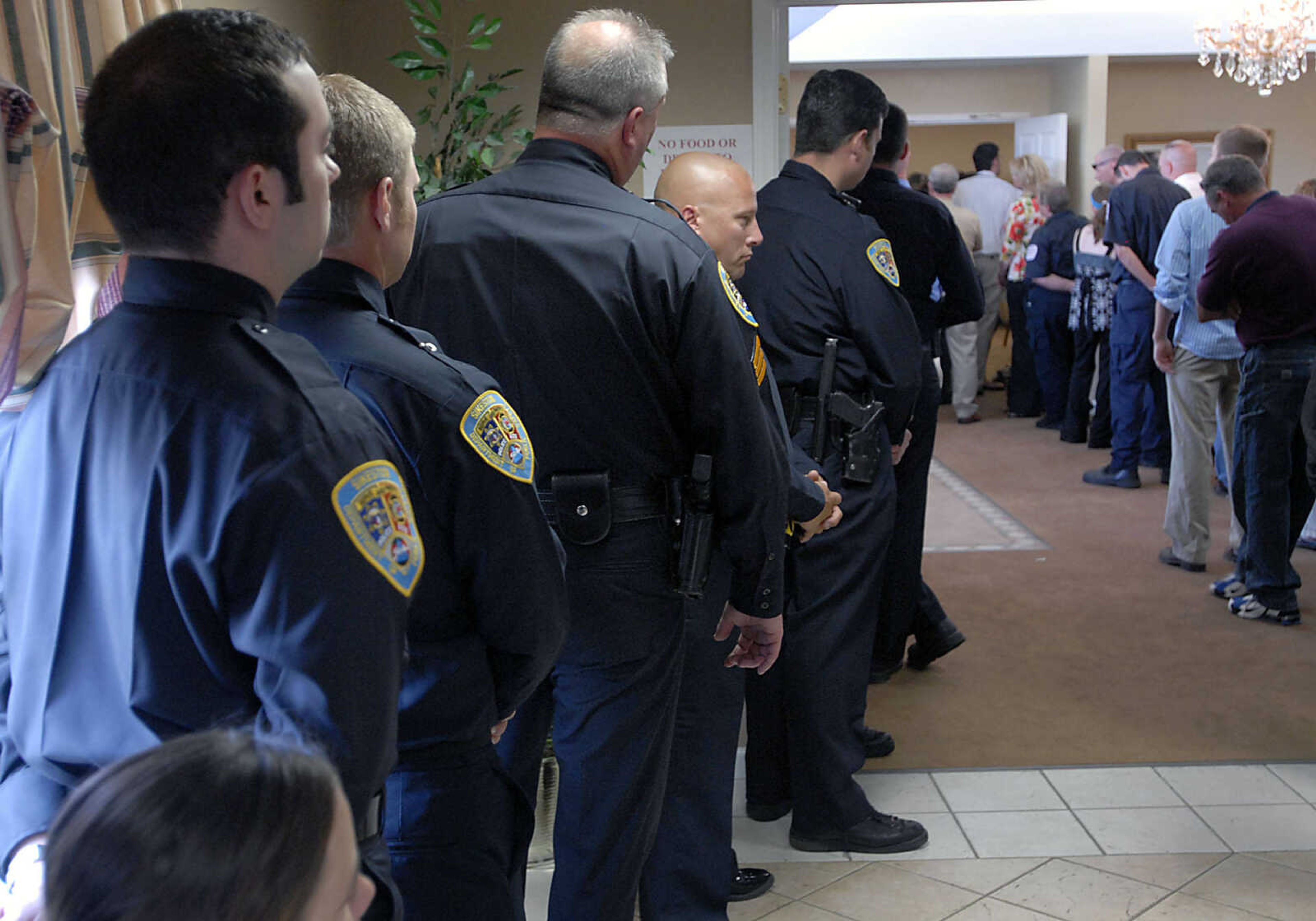 Emergency personnel listen to the Alexis Cummins funeral service from outside the chapel Wednesday, June 3, 2009, at Ponder Funeral Home in Sikeston.