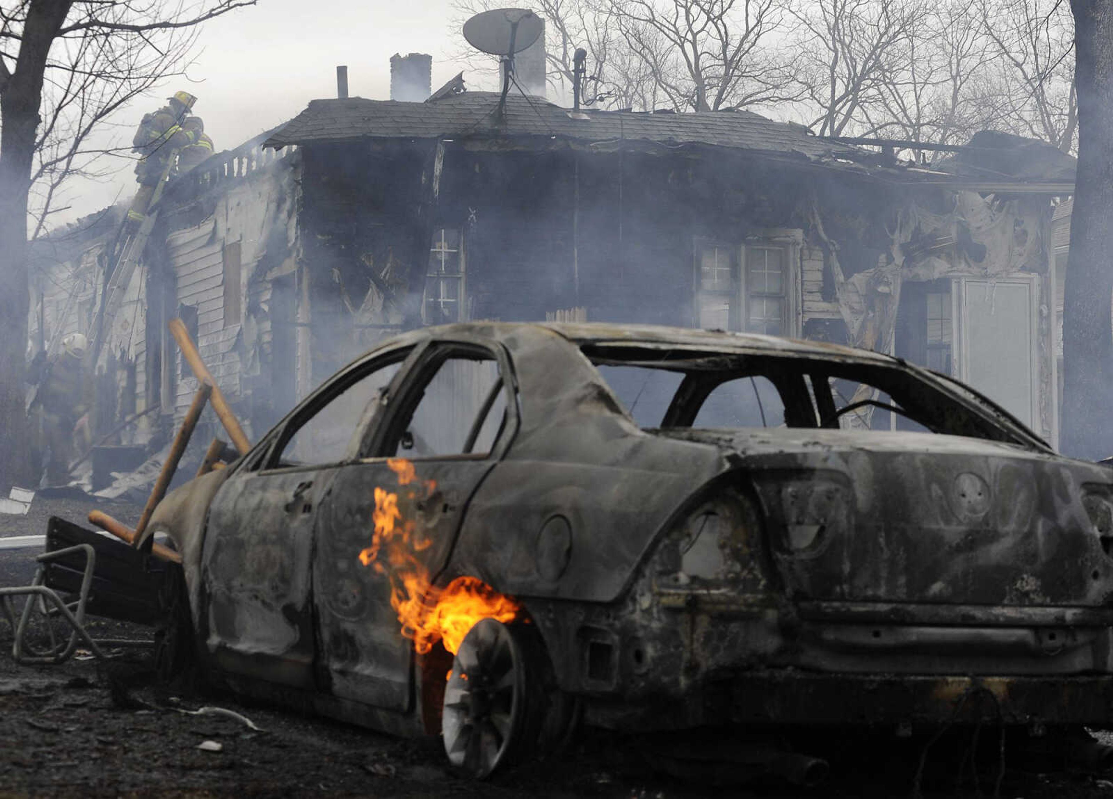 A car burns as firefighters battle a blaze at 429 E., Olive St., in Scott City Monday, March 4. Members of the Scott City, Cape Girardeau and Cherokee fire departments responded to the scene of the fire which destroyed the house, a shed and a neighbor's car. (Adam Vogler)