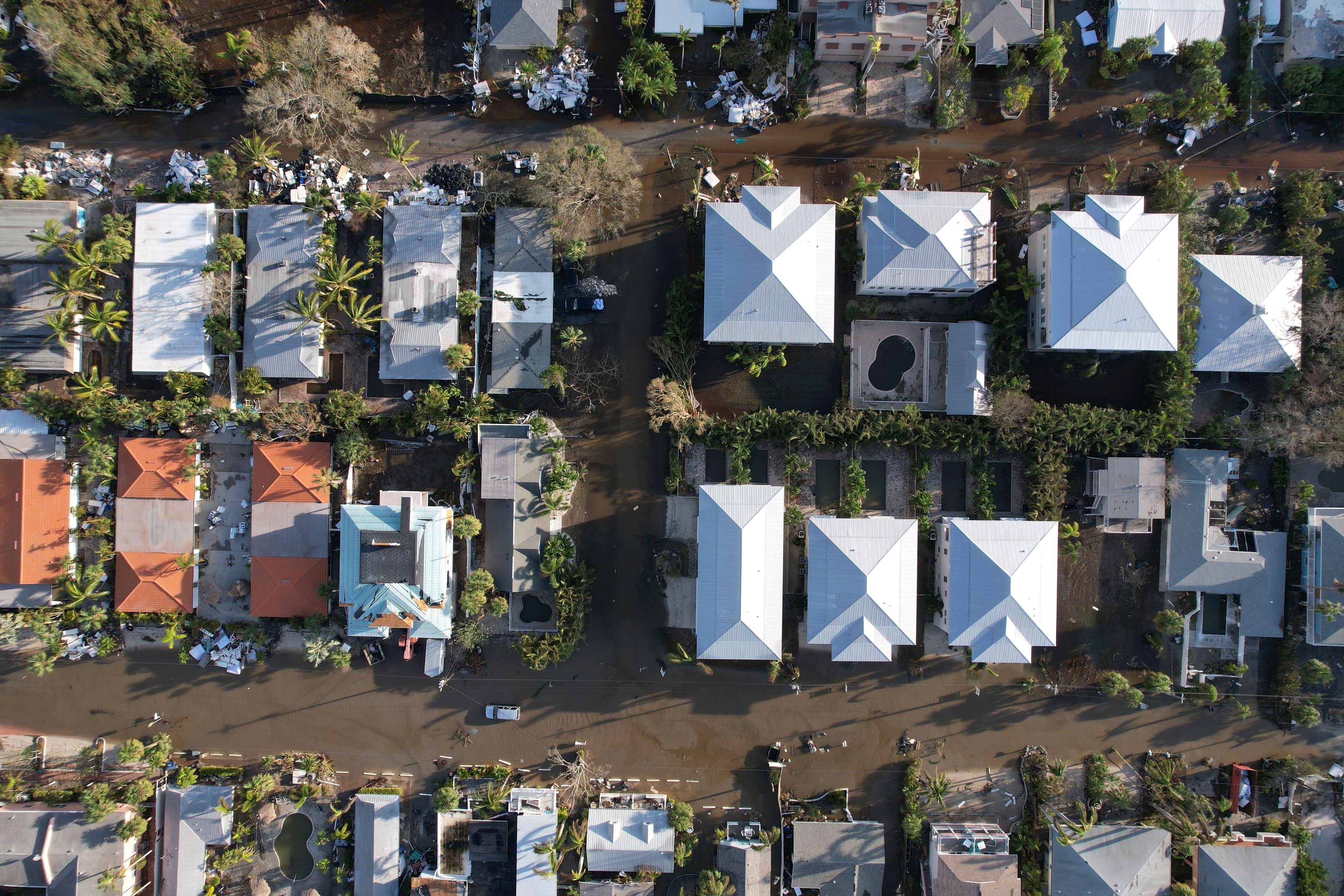 Flood waters recede after Hurricane Milton, on streets where piles of debris from Hurricane Helene flooding, sit outside many homes, in Siesta Key, Fla., Thursday, Oct. 10, 2024. (AP Photo/Rebecca Blackwell)