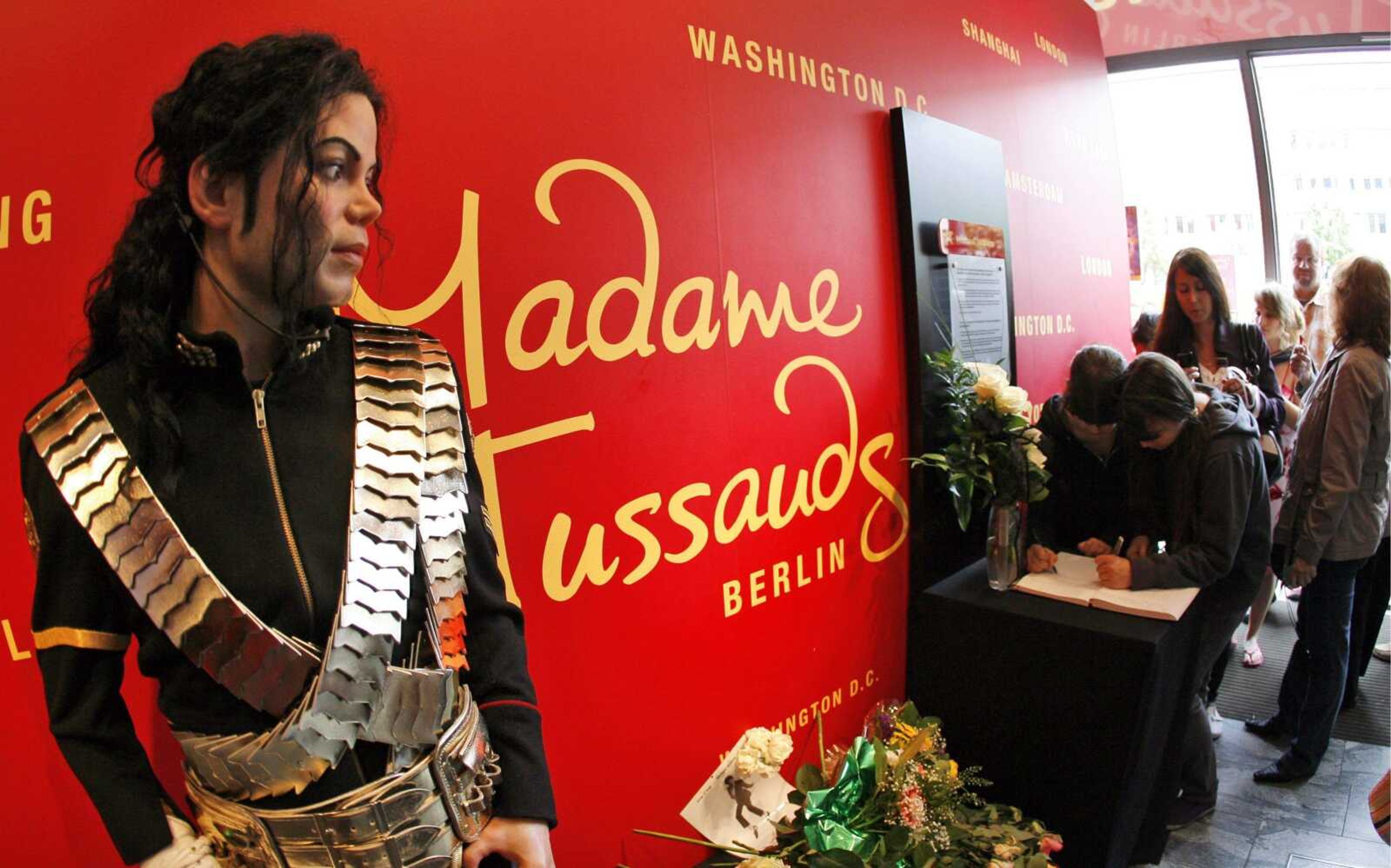 People sign the condolence book for late "King of Pop", Michael Jackson, at Madame Tussaud's  wax museum in Berlin, Germany, Saturday June 27, 2009. (AP Photo/Maya Hitij)