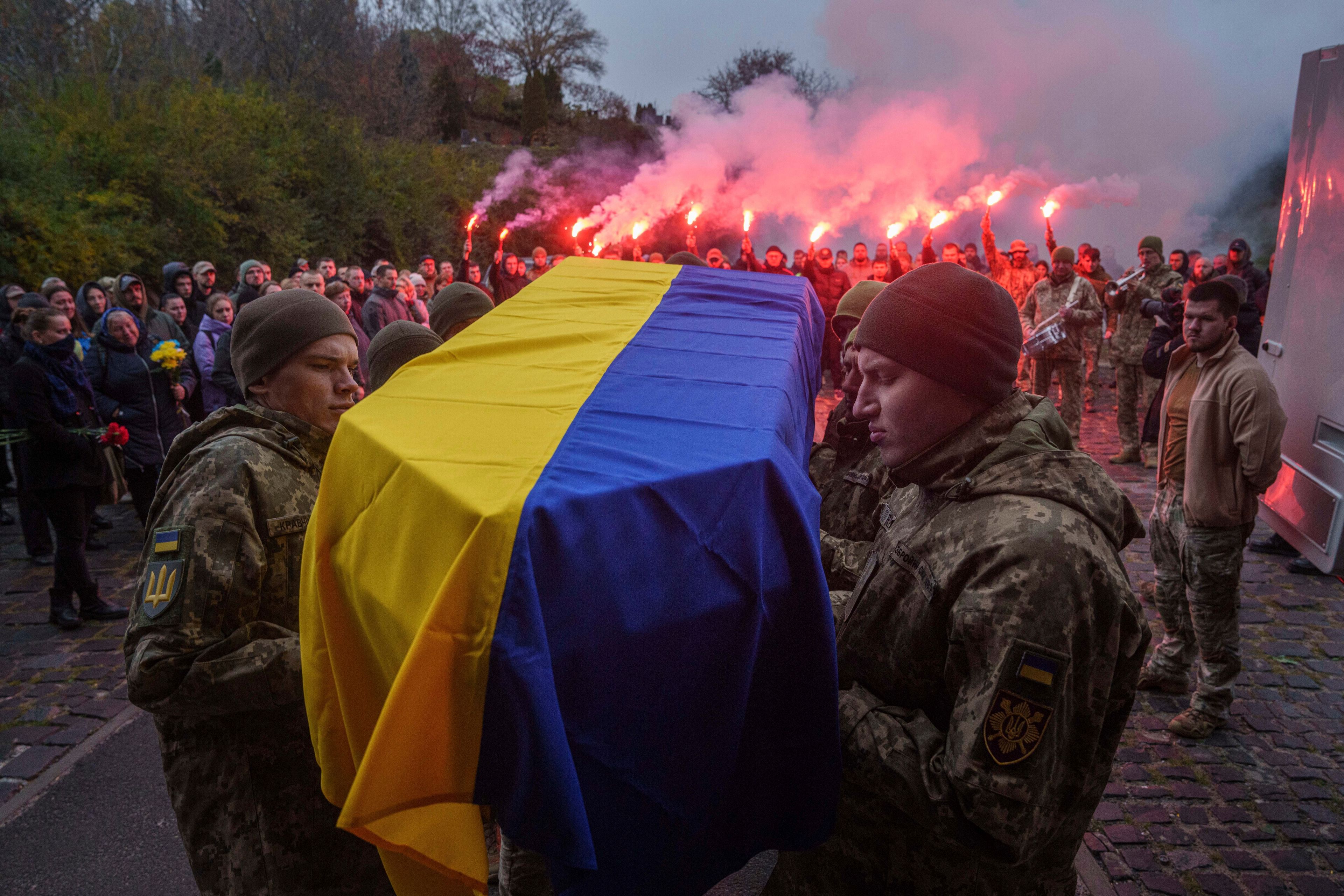 An honor guard carries the coffin of fallen Ukrainian serviceman of 3rd assault brigade Danylo Liashkevych, known as "Berserk", who was killed together with his girlfriend Valentyna Nagorna, known as "Valkiria", during the funeral ceremony at a crematorium in Kyiv, Ukraine, Friday Nov. 8, 2024. (AP Photo/Evgeniy Maloletka)