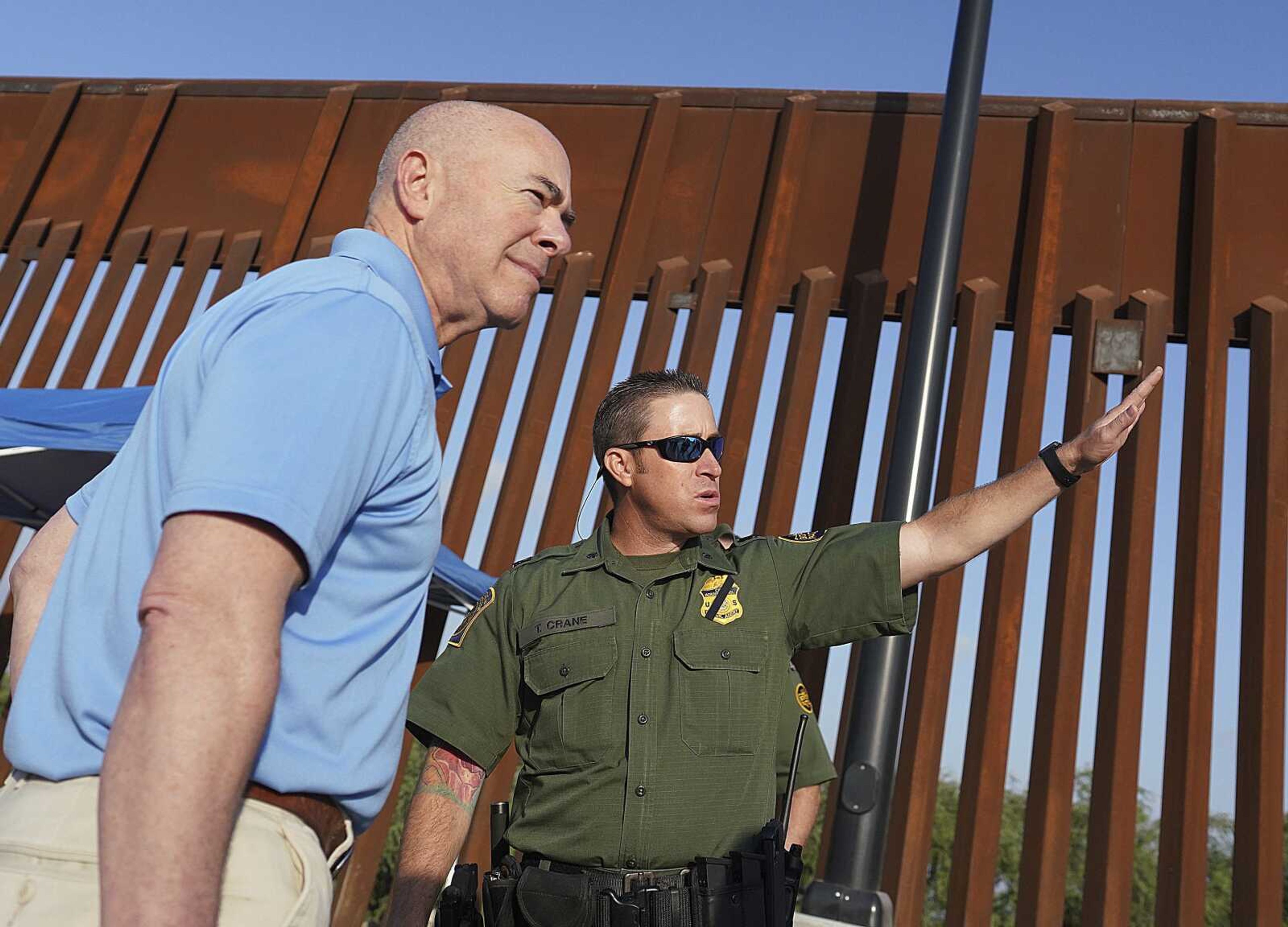 Homeland Security Secretary Alejandro Mayorkas, left, listens to deputy patrol agent in charge of the U.S. Border Patrol Anthony Crane as he tours the section of the border wall May 17 in Hidalgo, Texas.