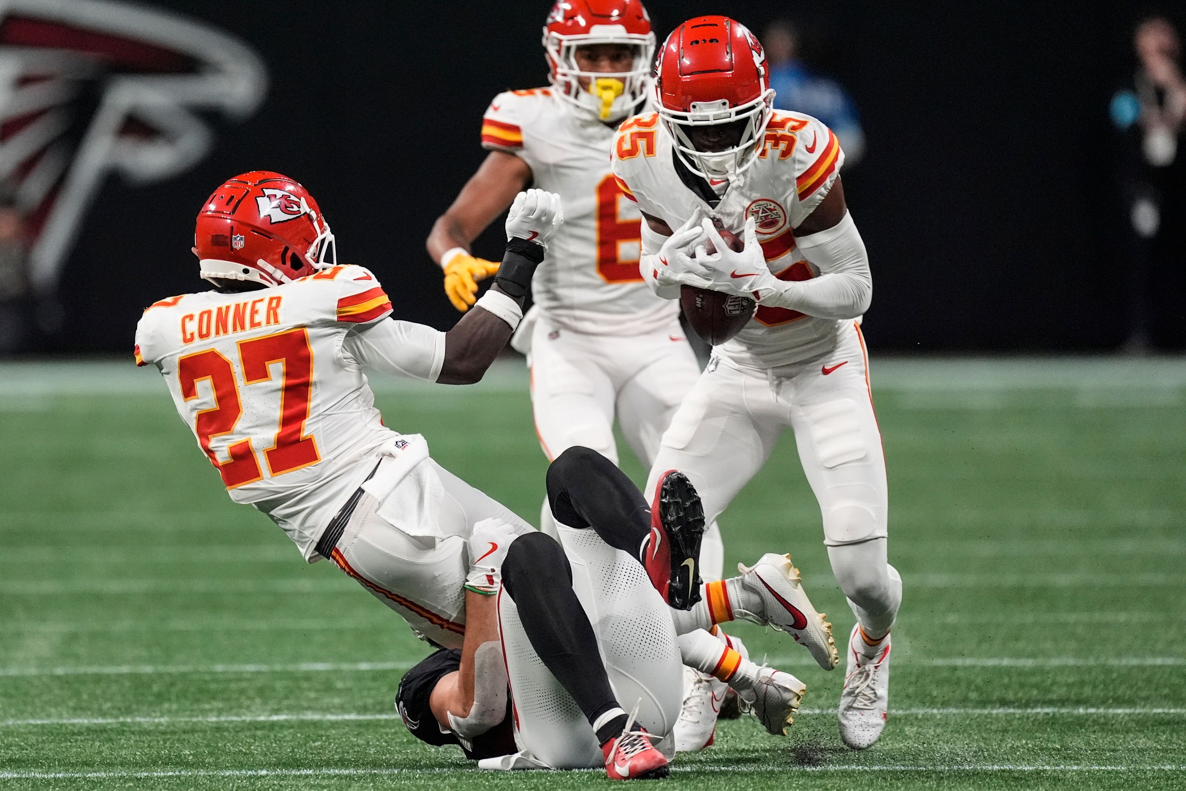 Kansas City Chiefs safety Chamarri Conner (27) laterals the ball to cornerback Jaylen Watson (35) after an interception against the Atlanta Falcons during the first half of an NFL football game, Sunday, Sept. 22, 2024, in Atlanta. (AP Photo/John Bazemore)