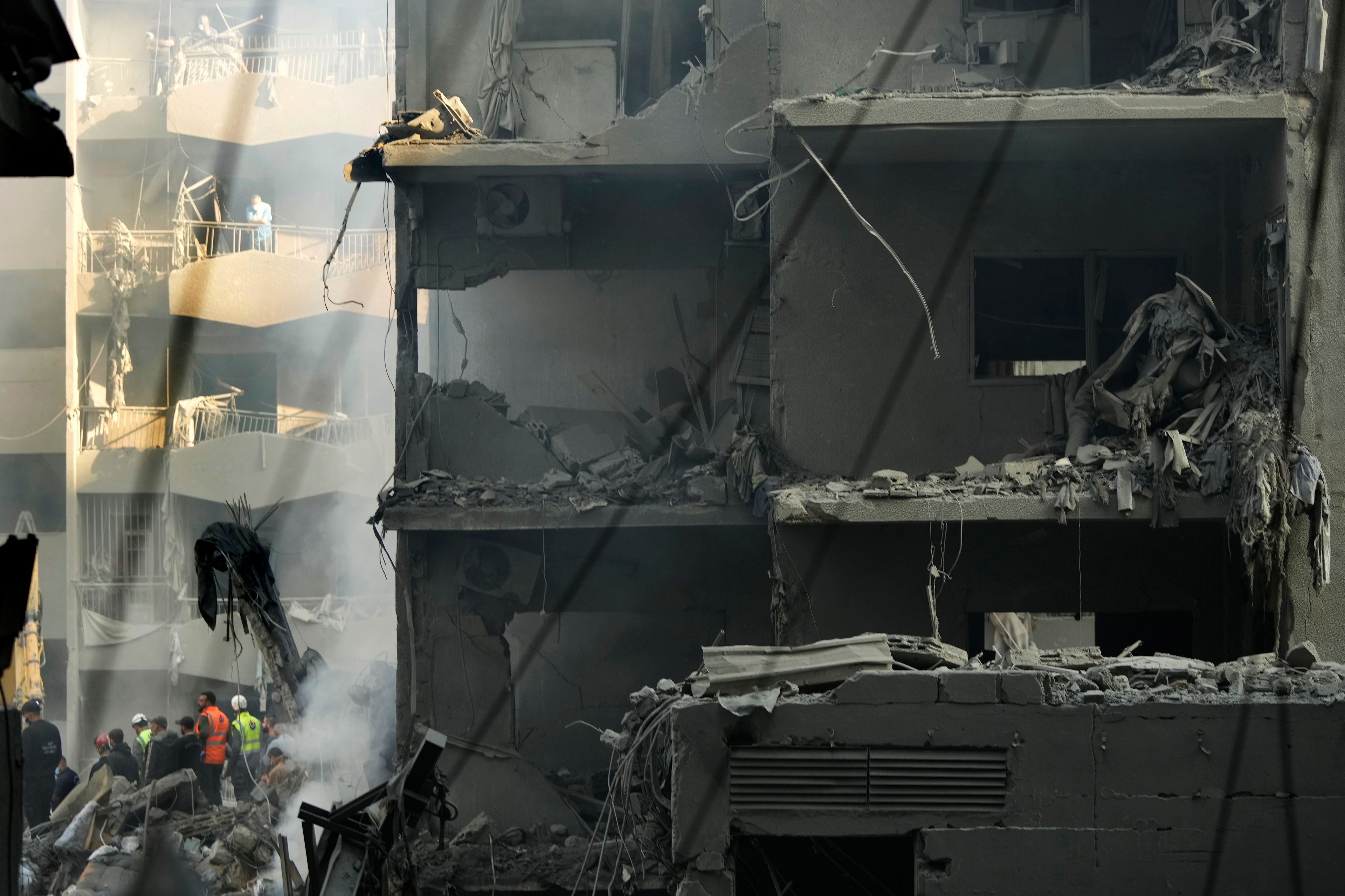 Rescue workers and people gather at the site of an Israeli airstrike that hit central Beirut, Lebanon, Saturday, Nov. 23, 2024. (AP Photo/Hassan Ammar)