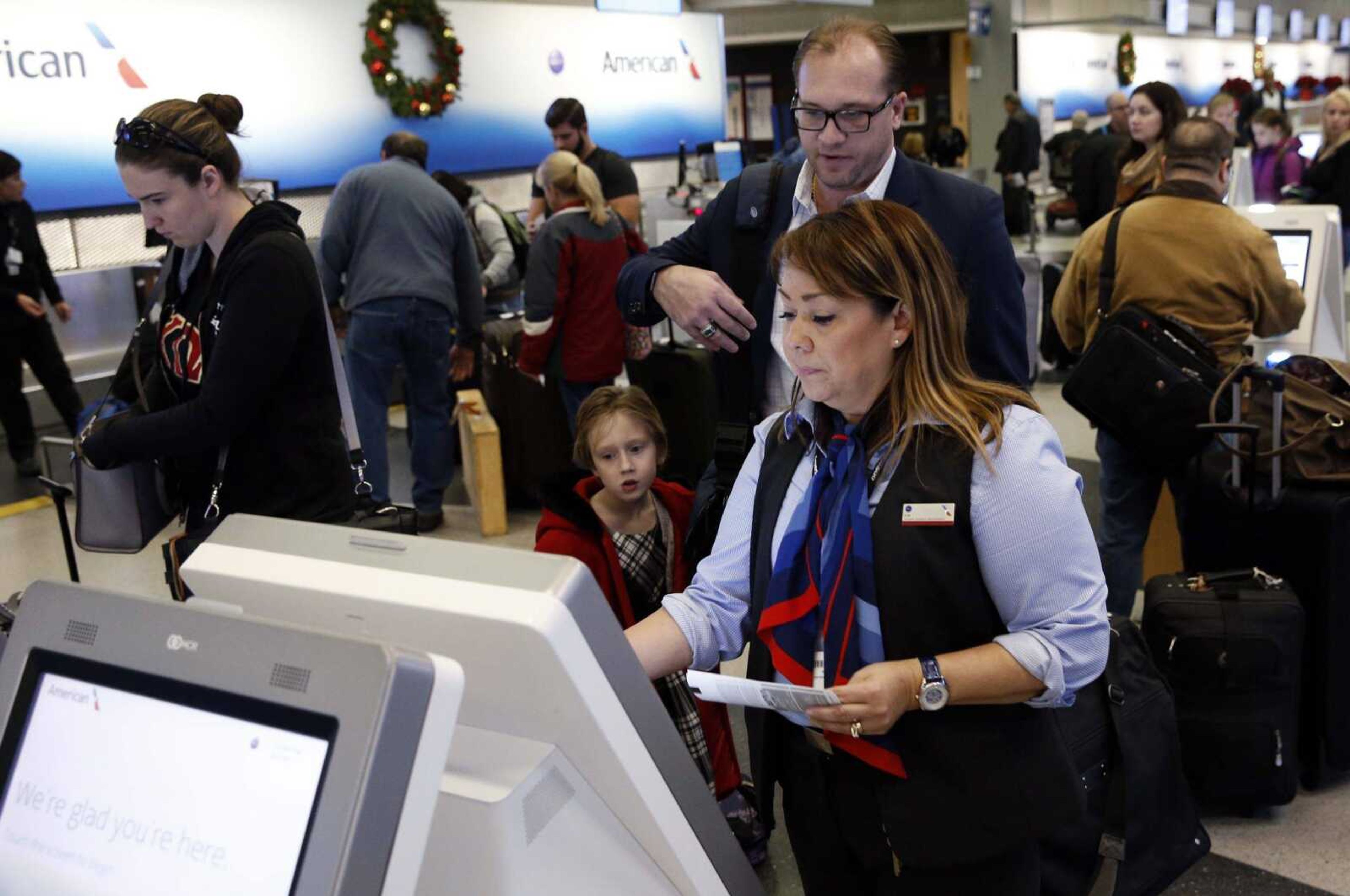 Travelers check in at the American Airlines ticket counter the day before Thanksgiving, Nov. 23, 2016, at Chicago's O'Hare Airport.