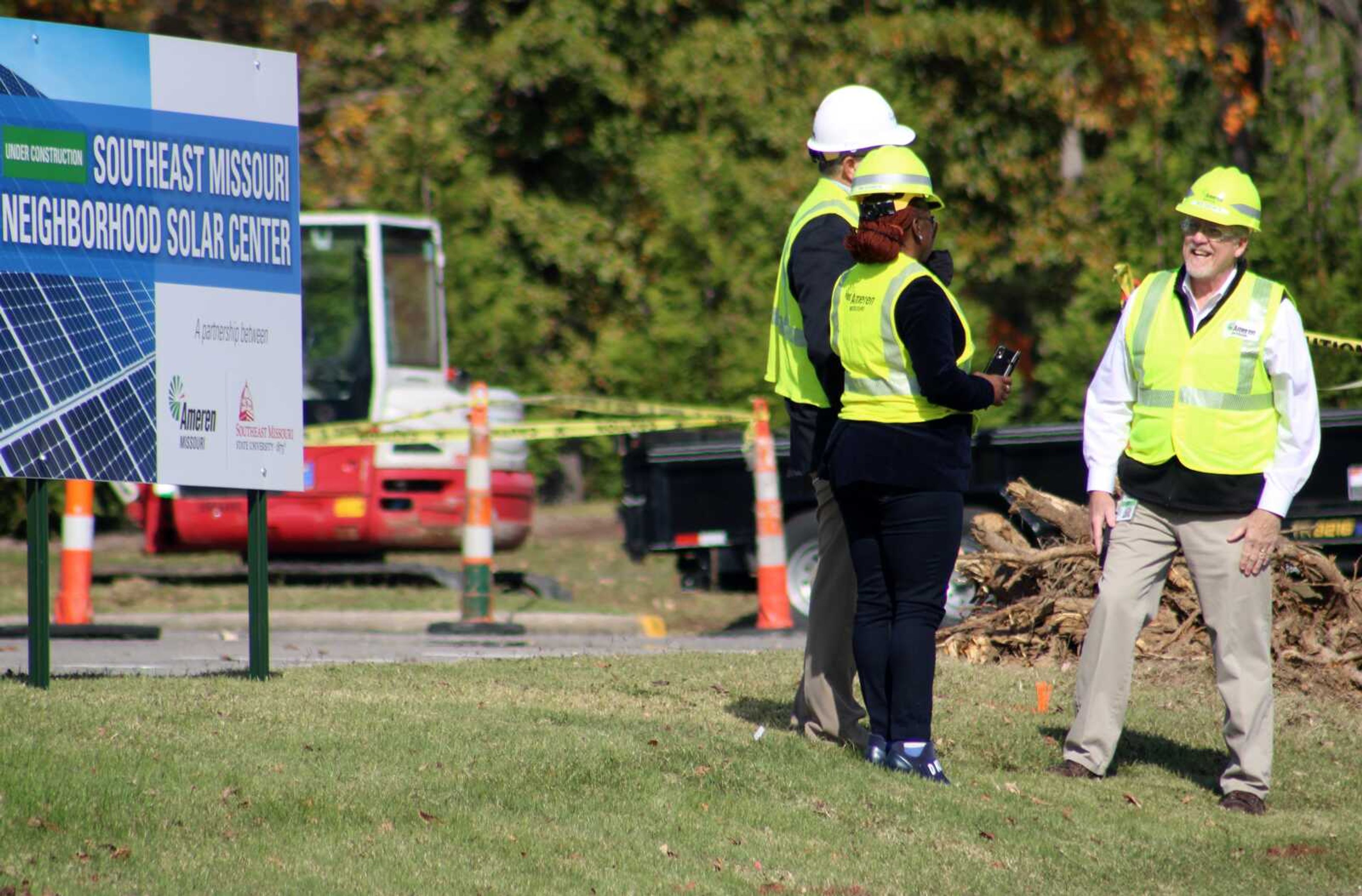 Representatives of Ameren Missouri stand in front of the Southeast Missouri Neighborhood Solar Center sign Wednesday in the Show Me Center parking lot in Cape Girardeau.