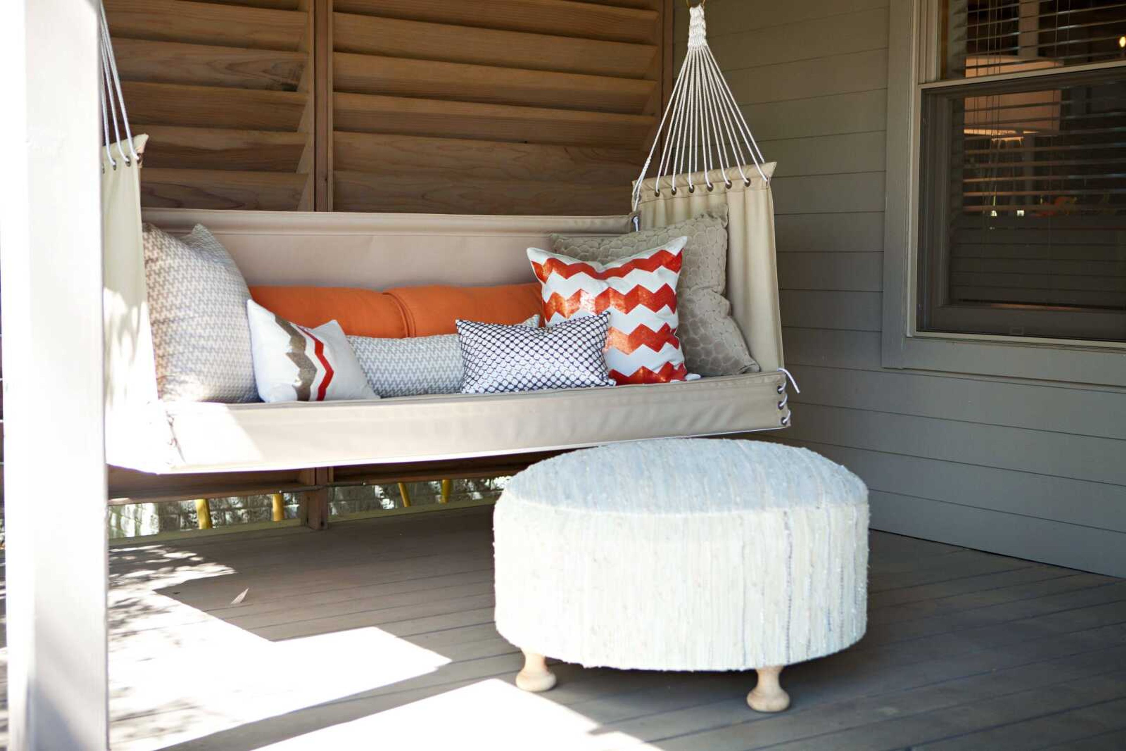 This photo provided by Abbe Fenimore shows how sofa pillows, as seen in this outdoor seating area designed by Texas-based interior designer Abbe Fenimore, bring a touch of indoor comfort to a deck or patio. If a front porch has enough space, comfortable seating like this can create the feeling of an outdoor room.