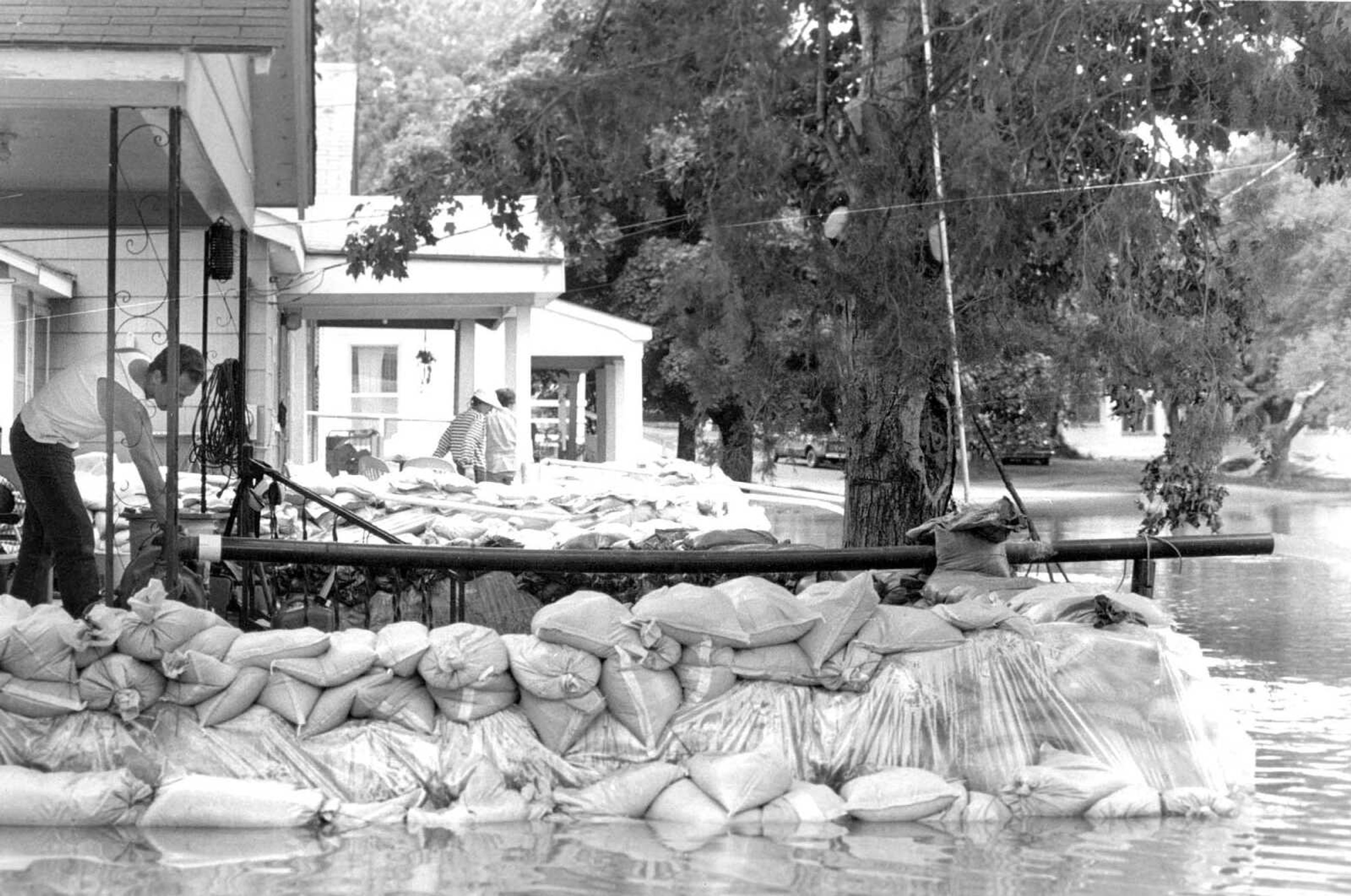 Published Aug. 6, 1993
Bryan Hartis of 1401 Water St., in the Red Star district, pumps water out of his sandbag-protected home on Thursday, along with other members of the community who are fighting to keep the floodwaters from damaging their property. (Missourian archive photo by Melina A. Mara)