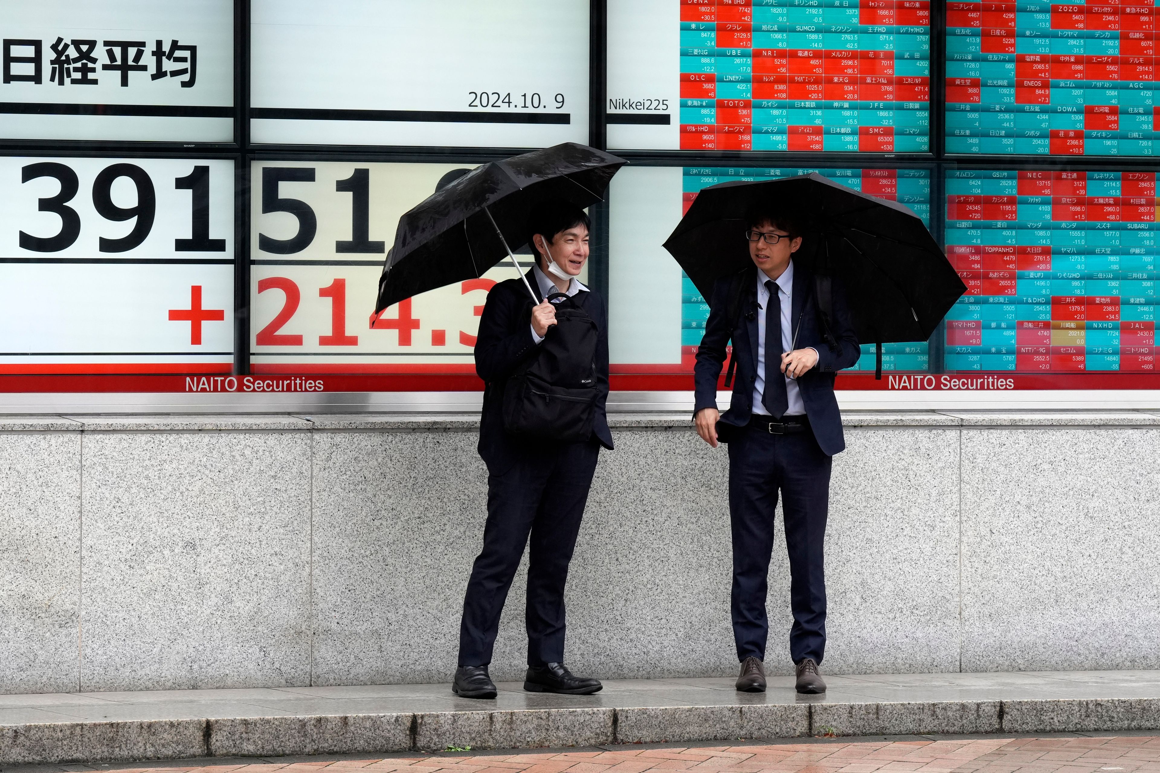 People stand in front of an electronic stock board showing Japan's Nikkei index at a securities firm, Wednesday, Oct. 9, 2024, in Tokyo. (AP Photo/Eugene Hoshiko)