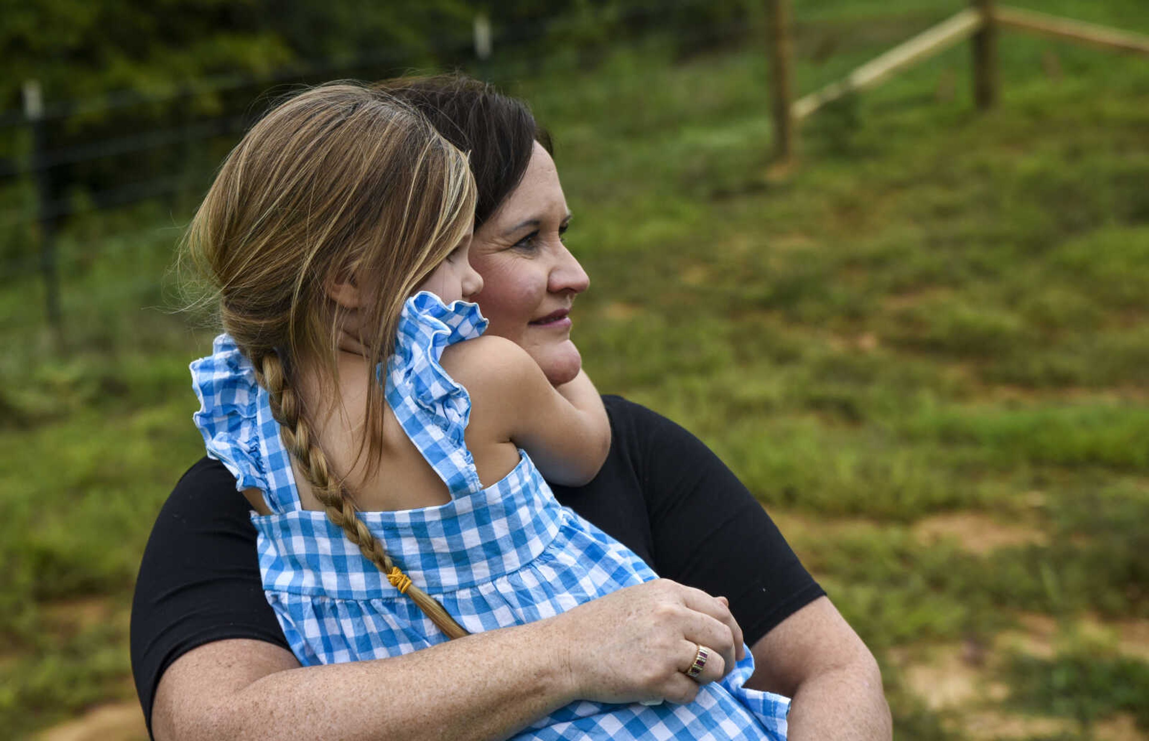 Michell Prichard holds Iva Mae Prichard, 4, as they watch Nate Prichard, 5, (not pictured) ride his new horse in their backyard Monday, July 30, 2018 in&nbsp;Burfordville.