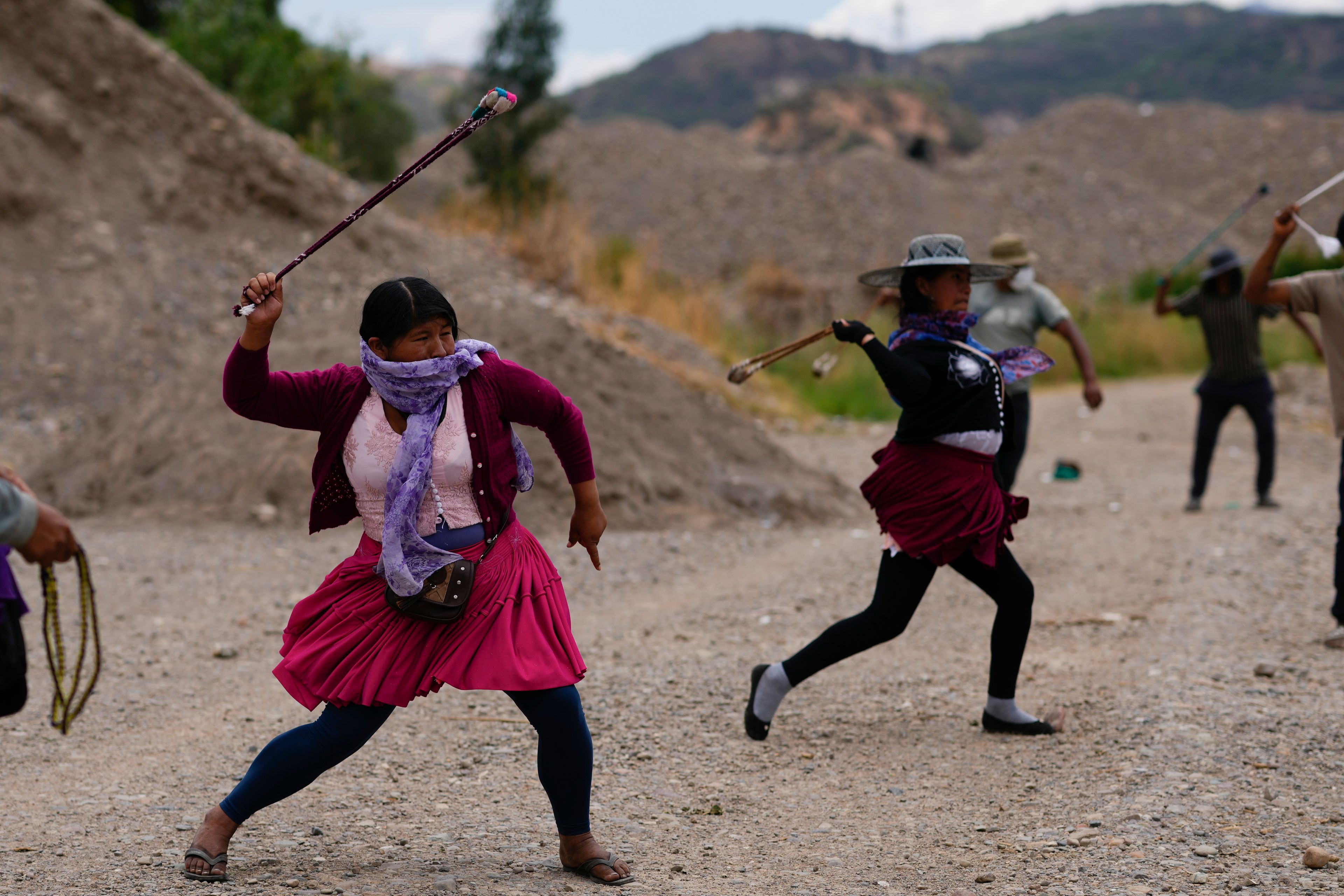 Protesters practice using slings as they block a road in support of former President Evo Morales in the face of an investigation opened against him for the alleged abuse of a minor while in office, in Parotani, Bolivia, Thursday, Oct. 31, 2024. (AP Photo/Juan Karita)