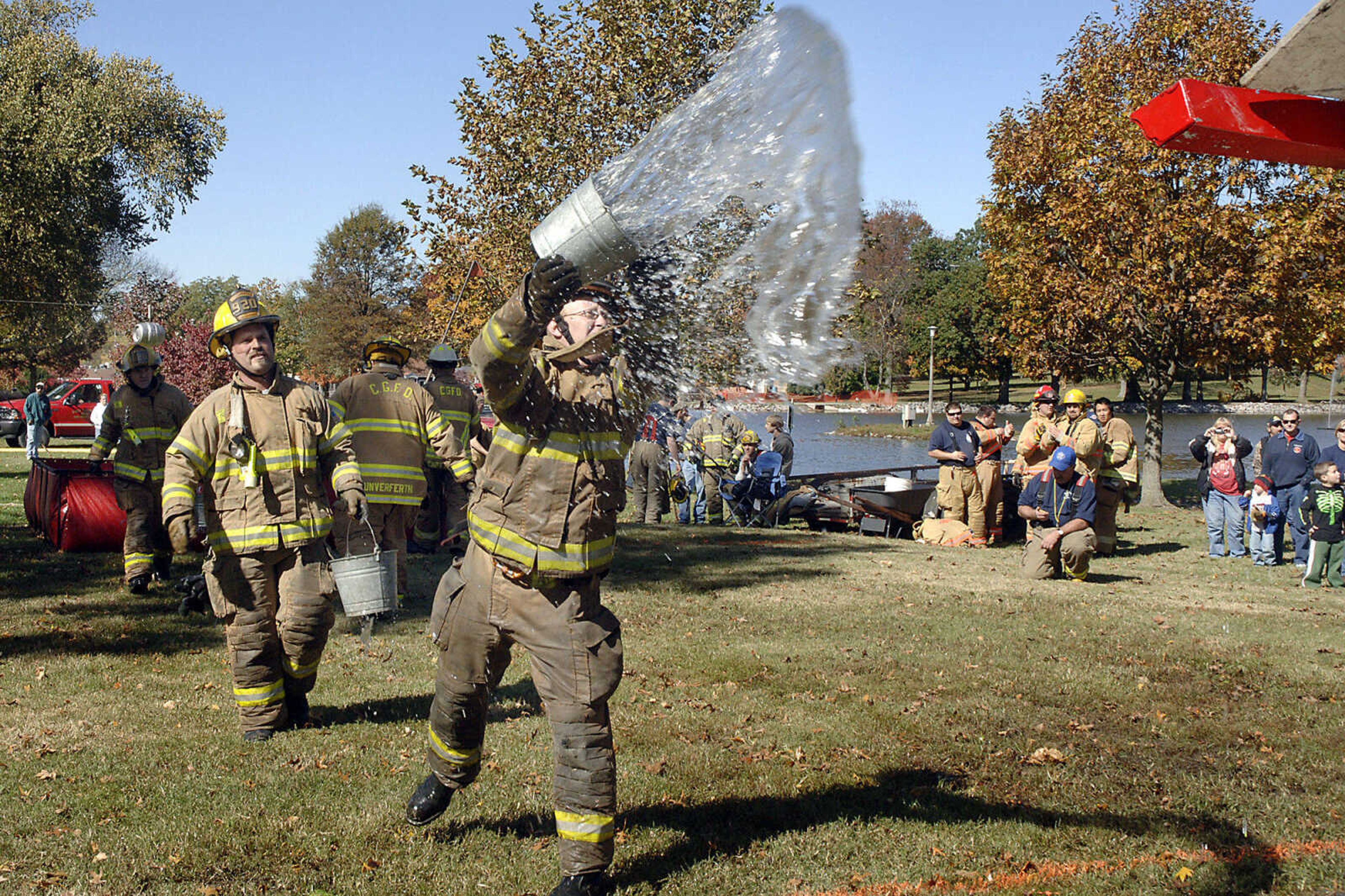 LAURA SIMON~photos@semissourian.com
Spectators watched as Cape Girardeau Firefighter Matt Mittrucker threw water onto a roof during a game called the bucket brigade Saturday at Capaha Park in Cape Girardeau, as it held the 6th annual Capaha Fire Truck Rally. There were more than seven fire departments involved in the rally, with four of them competing in the day's numerous competitions.