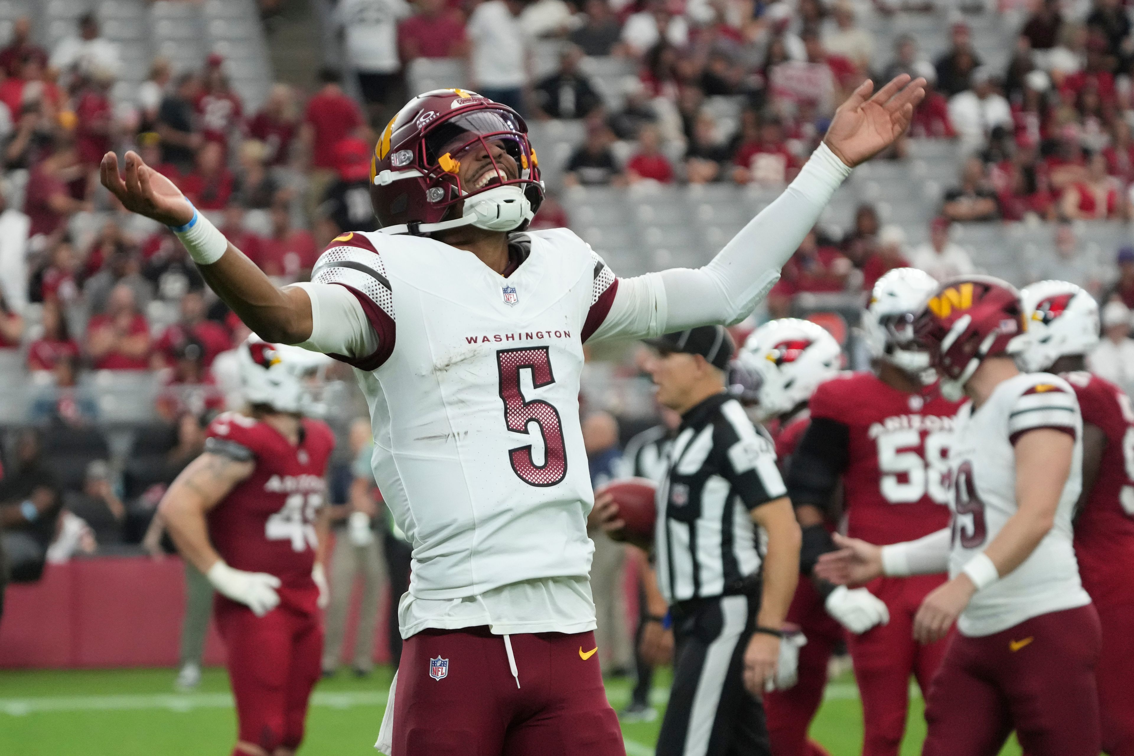 Washington Commanders quarterback Jayden Daniels (5) celebrates a touchdown against the Arizona Cardinals during the second half of an NFL football game, Sunday, Sept. 29, 2024, in Glendale, Ariz. (AP Photo/Rick Scuteri)