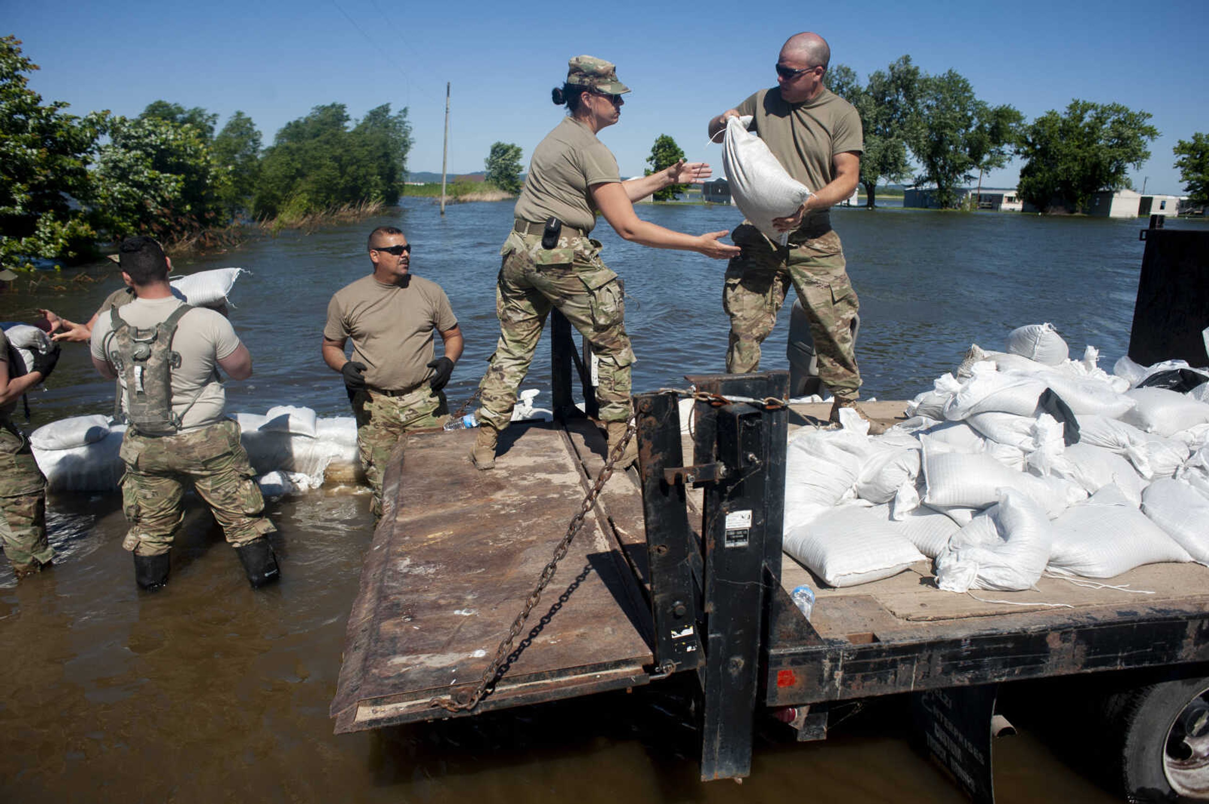 Members of the Illinois National Guard build up existing sandbag barriers to hold back floodwaters Monday, June 10, 2019, along Brookwood Drive in East Cape Girardeau, Illinois.