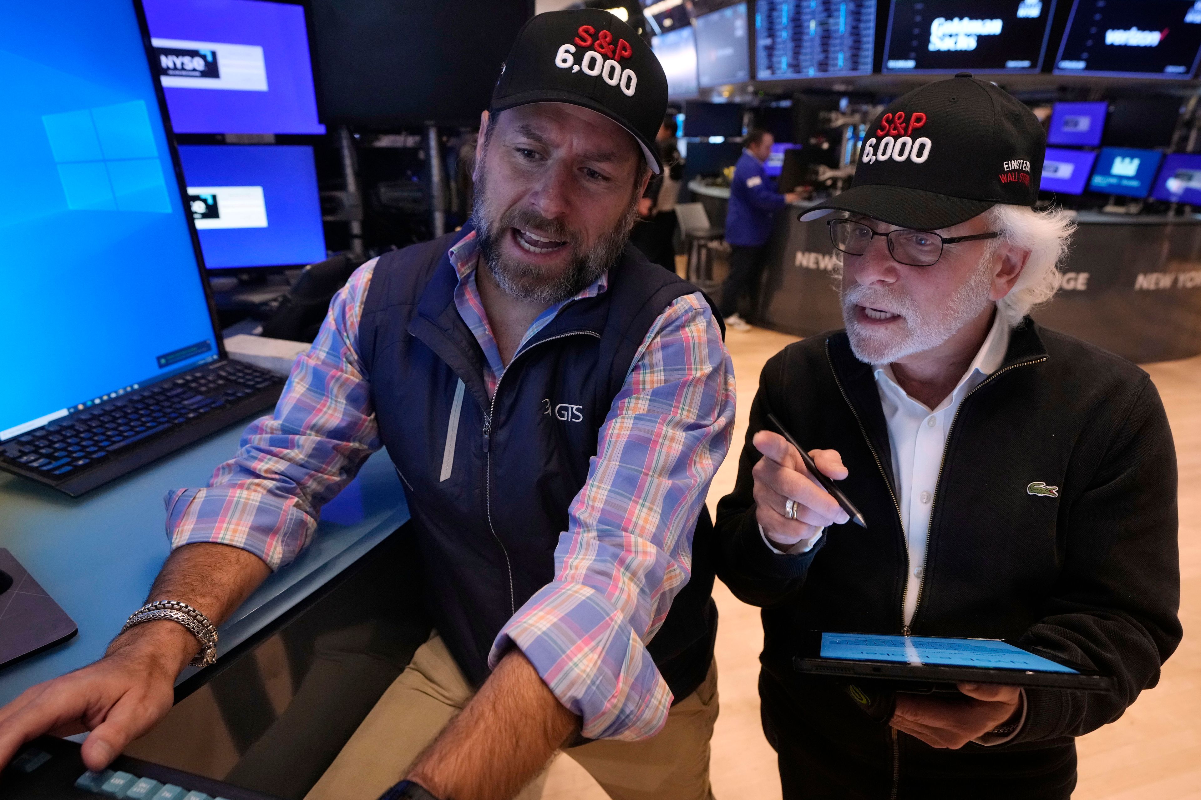 Specialist Mike Pistillo, left and trader Peter Tuchman wear "S&P 6000" hats on the floor of the New York Stock Exchange, Friday, Nov. 8, 2024. (AP Photo/Richard Drew)