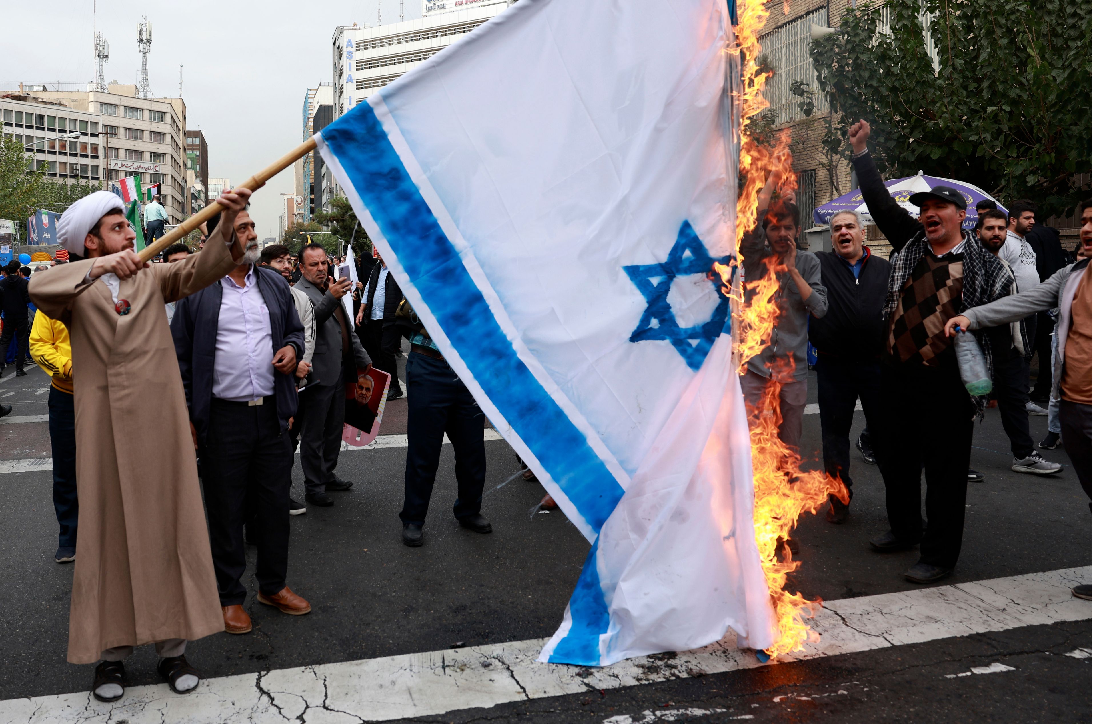 Iranian demonstrators burn a representation of the Israeli flag in an annual rally in front of the former U.S. Embassy in Tehran, Iran, Sunday, Nov. 3, 2024, marking the 45th anniversary of Iranian students' takeover of the embassy, starting a hostage crisis. (AP Photo/Vahid Salemi)