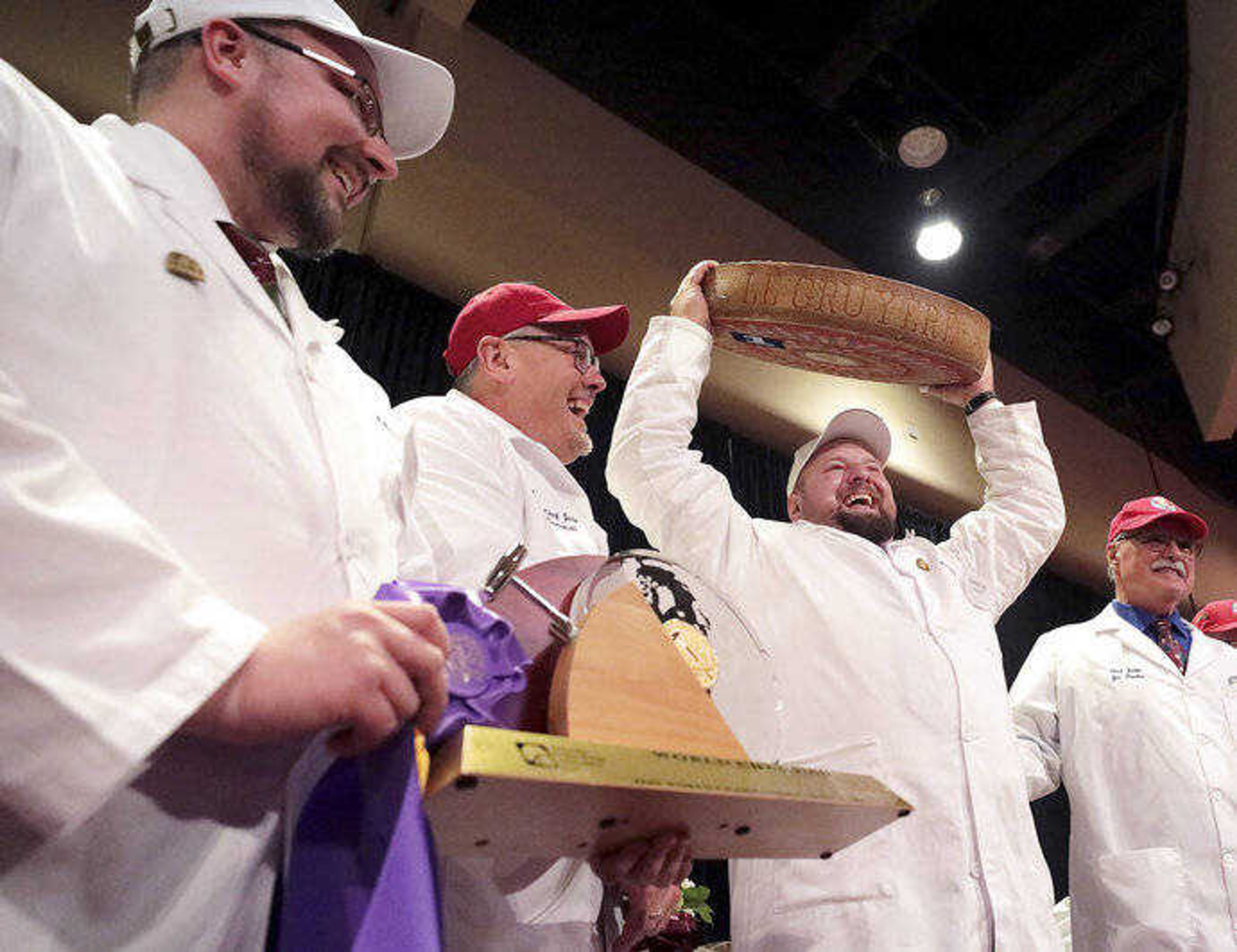 Christian Schmutz of the Swiss Cheesemakers Association hoists a 77-pound wheel of the Best of Show winner in the World Championship Cheese Contest on March 5 at Monona Terrace in Madison, Wisconsin. The cheese, Gourmino Le Gruyere, is made by Michael Spycher of Mountain Dairy Fritzenhaus for Gourmino AG.