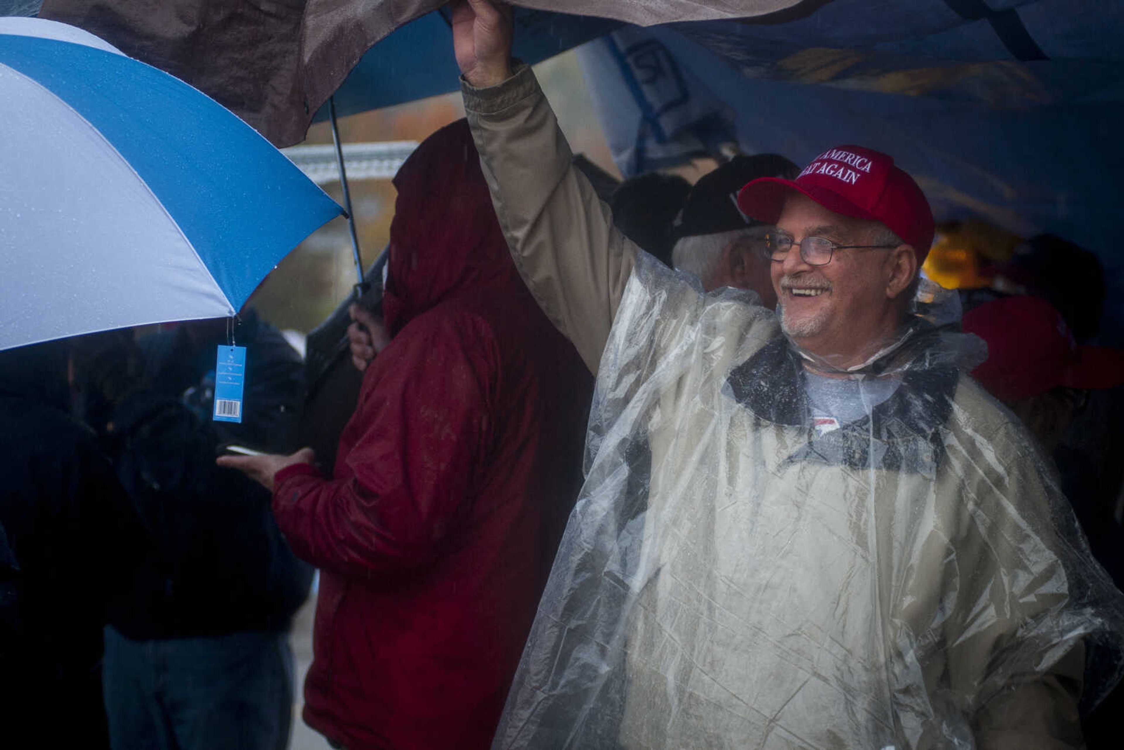 Ron Johnson, 59, of Harviell, Missouri, seeks shelter while waiting outside of the Show Me Center in the rain Monday, Nov. 5, 2018, in Cape Girardeau. "I've never seen a live President," Johnson said.