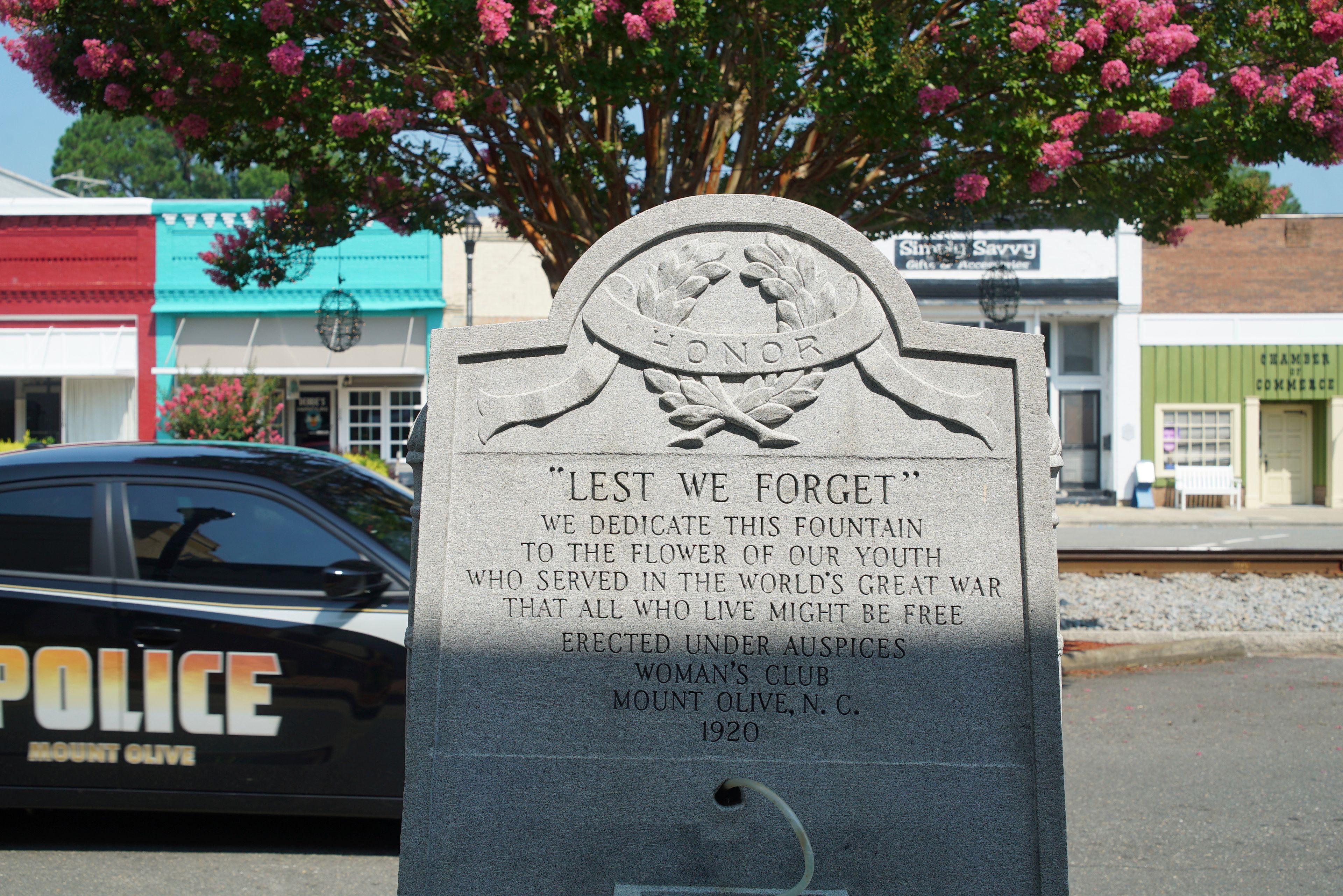 A police car passes a World War I memorial on Center Street in downtown Mount Olive, N.C., on Monday, July 15, 2024. (AP Photo/Allen G. Breed)