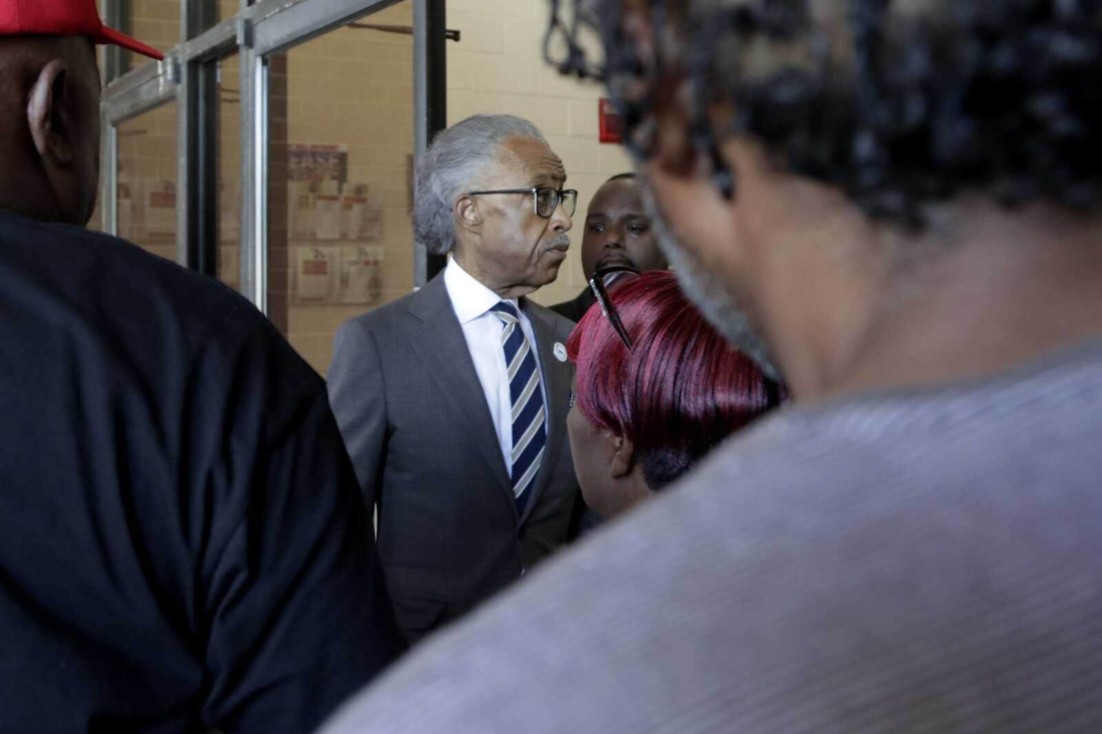 The Rev. Al Sharpton, center, president of National Action Network, enters New Shiloh Baptist Church after talking to reporters Monday in Baltimore.