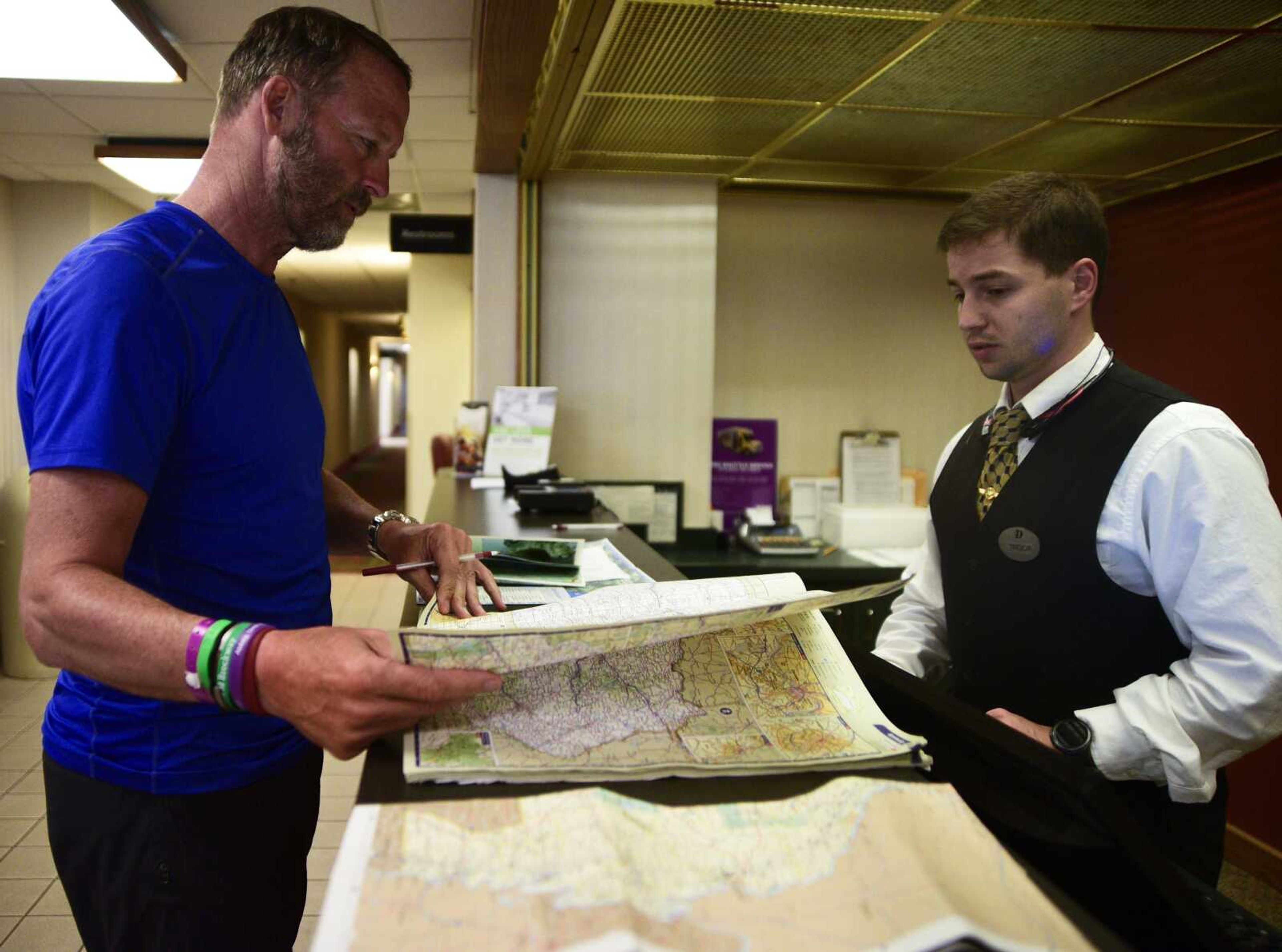 Bill Conner looks at maps in the hotel lobby of the Pear Tree Inn on his journey from  Wisconsin to Florida for organ-donor awareness.