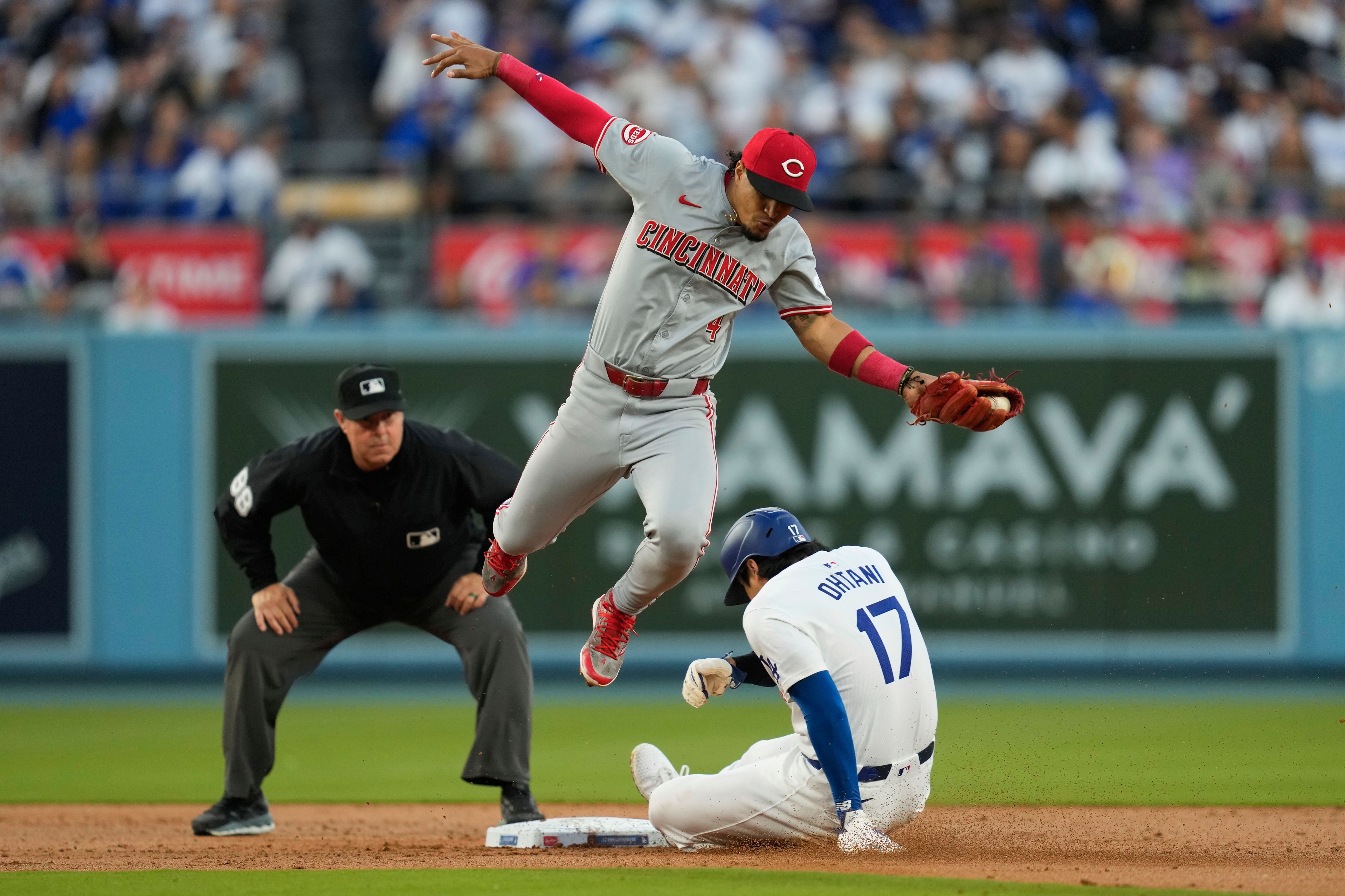 Los Angeles Dodgers designated hitter Shohei Ohtani (17) steals second base ahead of a throw to Cincinnati Reds second baseman Santiago Espinal (4) during the first inning of a baseball game in Los Angeles, Thursday, May 16, 2024. (AP Photo/Ashley Landis)